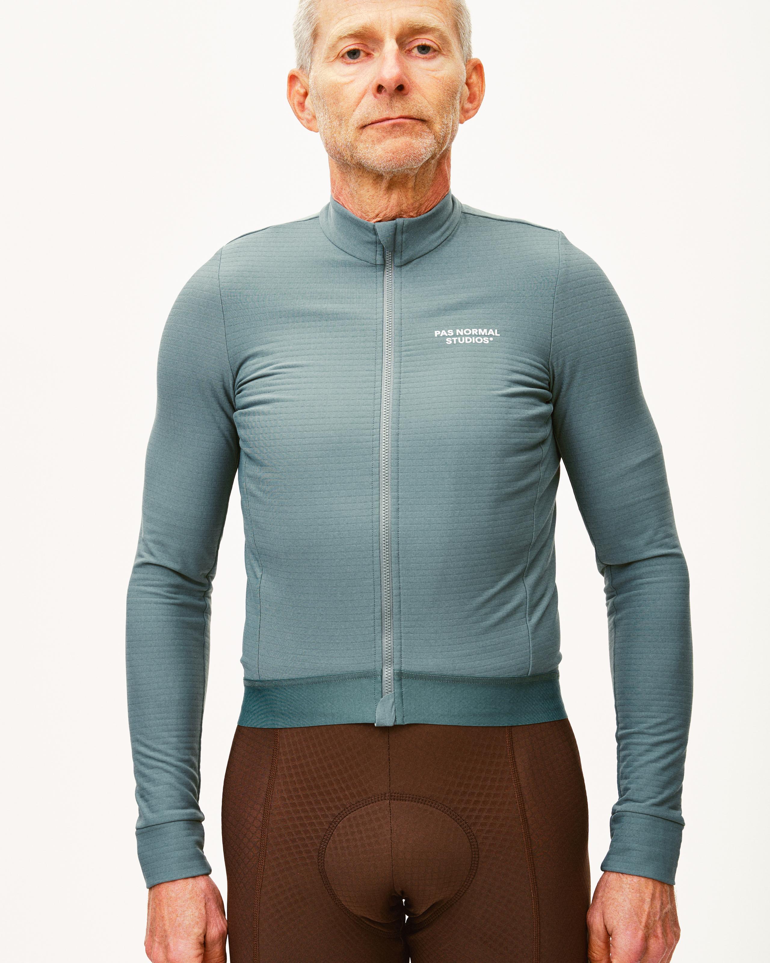 Grey Essential long sleeve cycling jersey on model with full zip and white chest logo