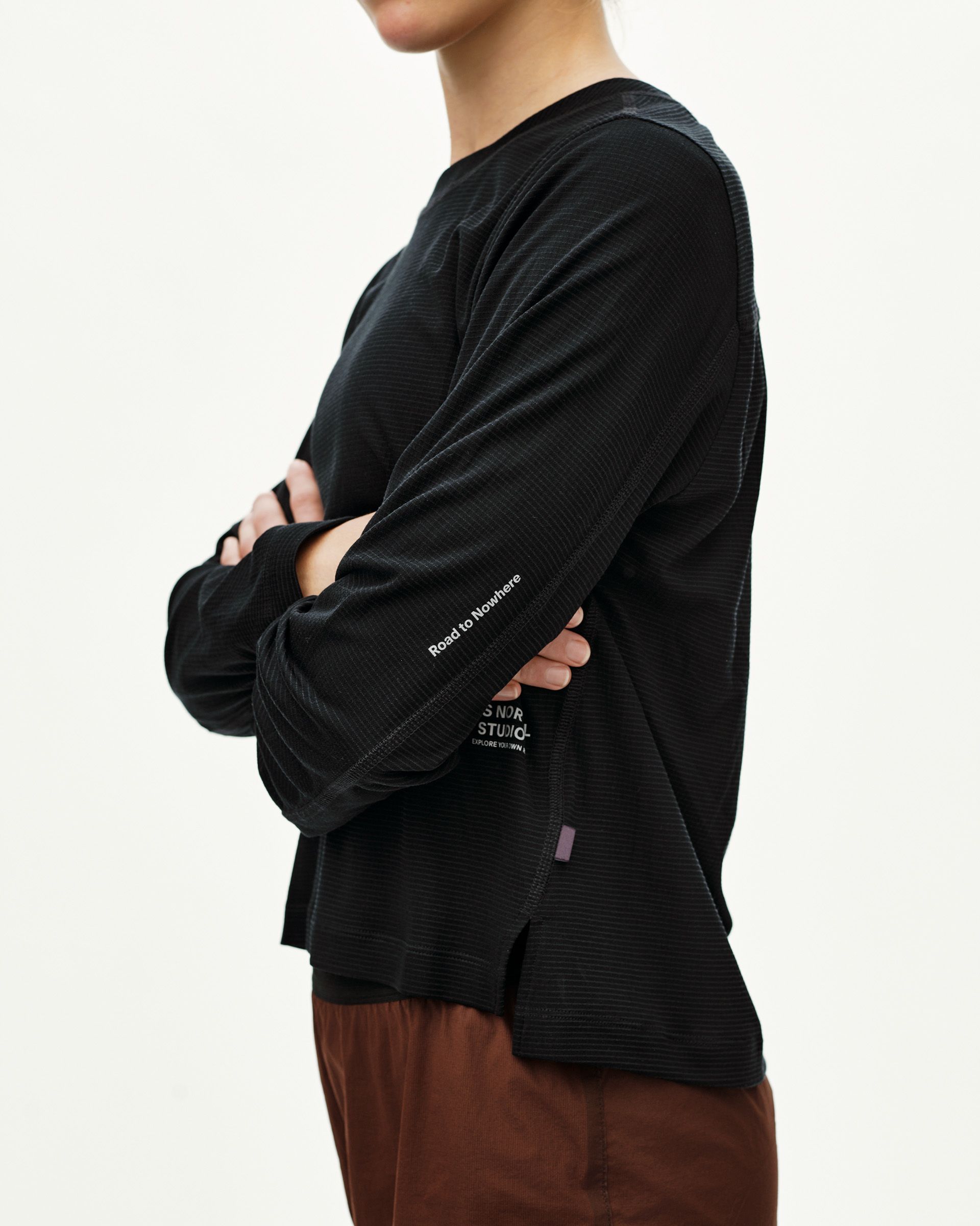 Black Balance long sleeve T-shirt on model, side view with sleeve text print and ribbed texture