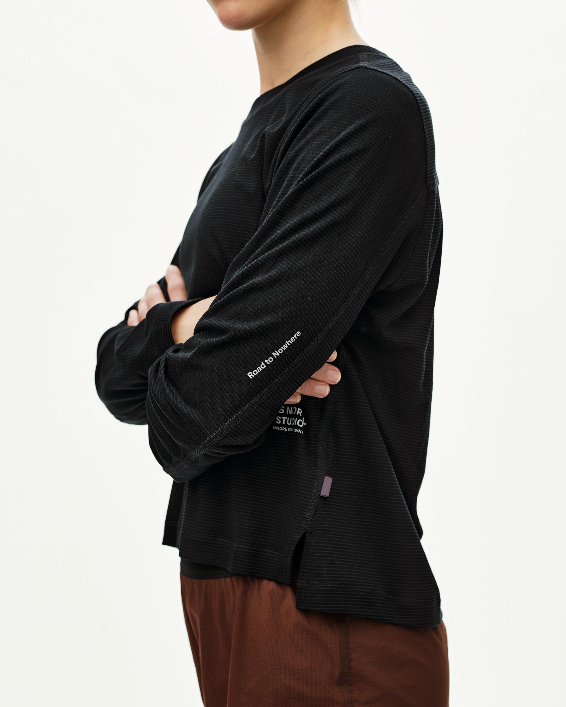 Black Balance long sleeve T-shirt on model, side view with sleeve text print and ribbed texture