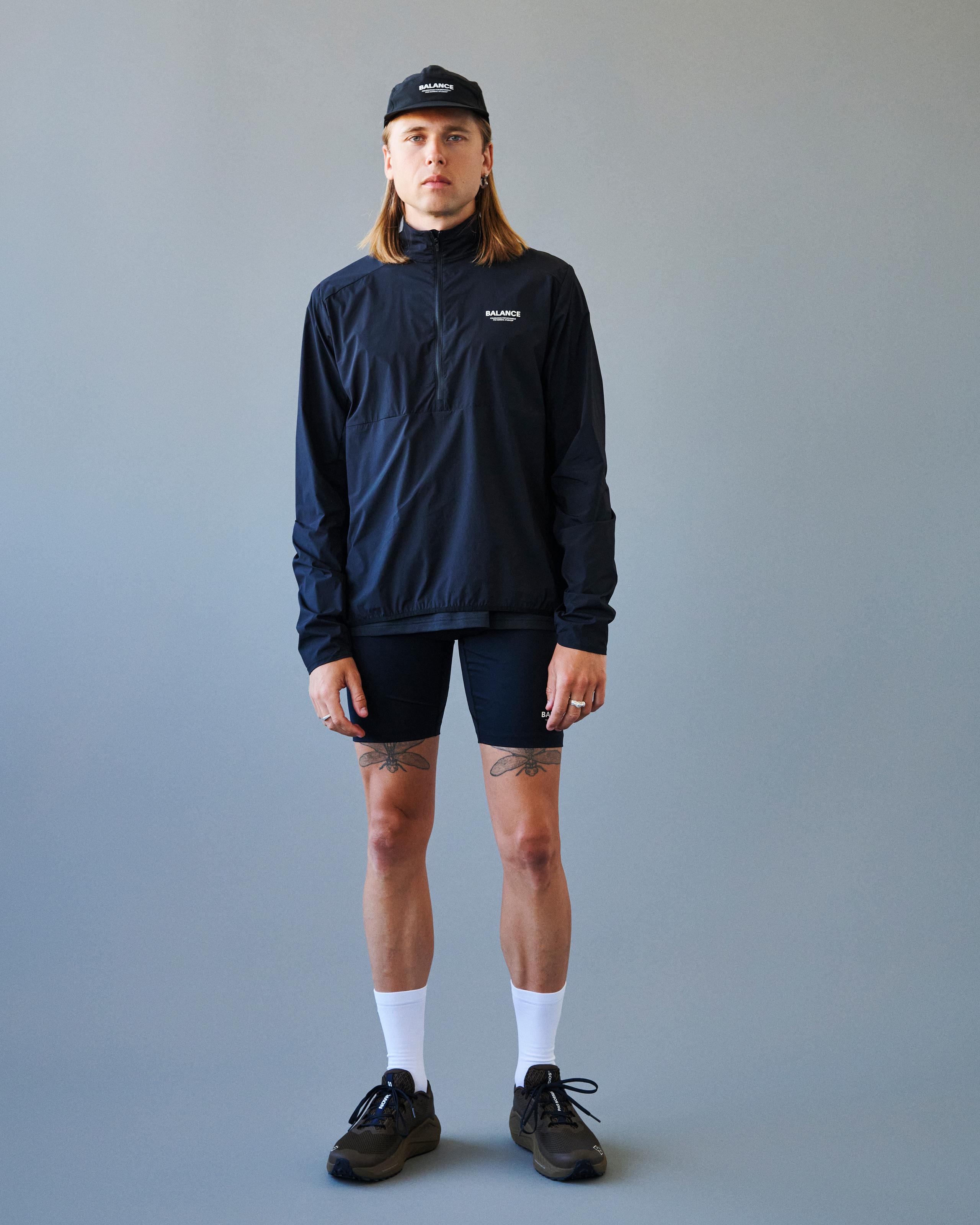 Black Balance Half Zip jacket on model with white chest logo