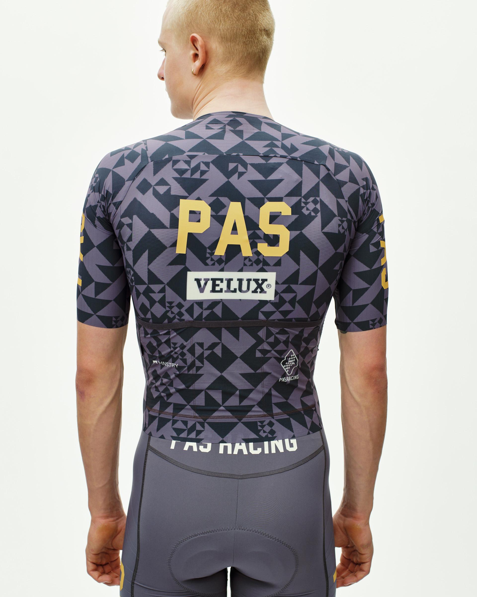 Origami Grey PAS Mechanism Pro cycling jersey on model, rear view with geometric print and yellow PAS back logo