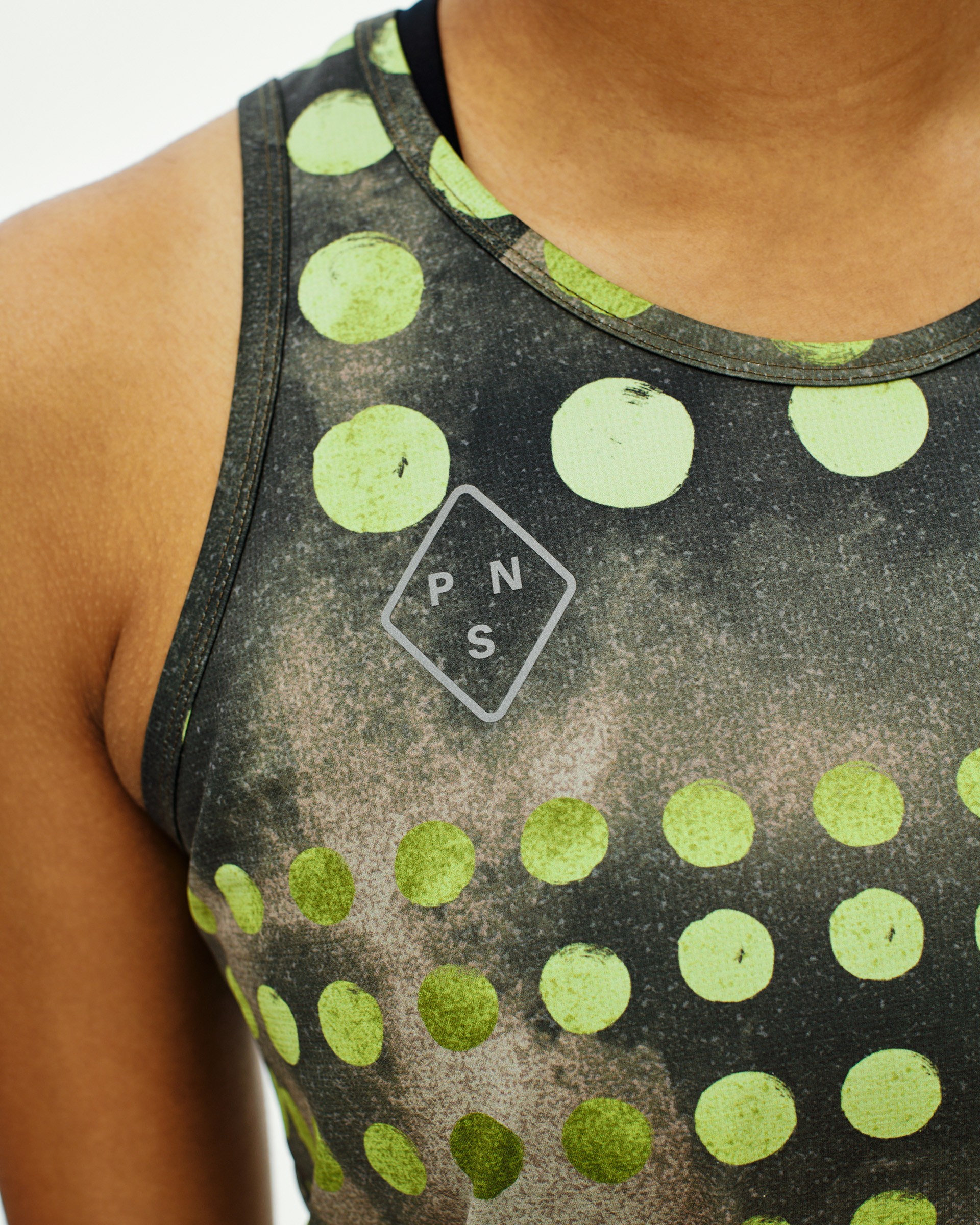 Green T.K.O. Balance singlet on model with polka dot print and chest logo