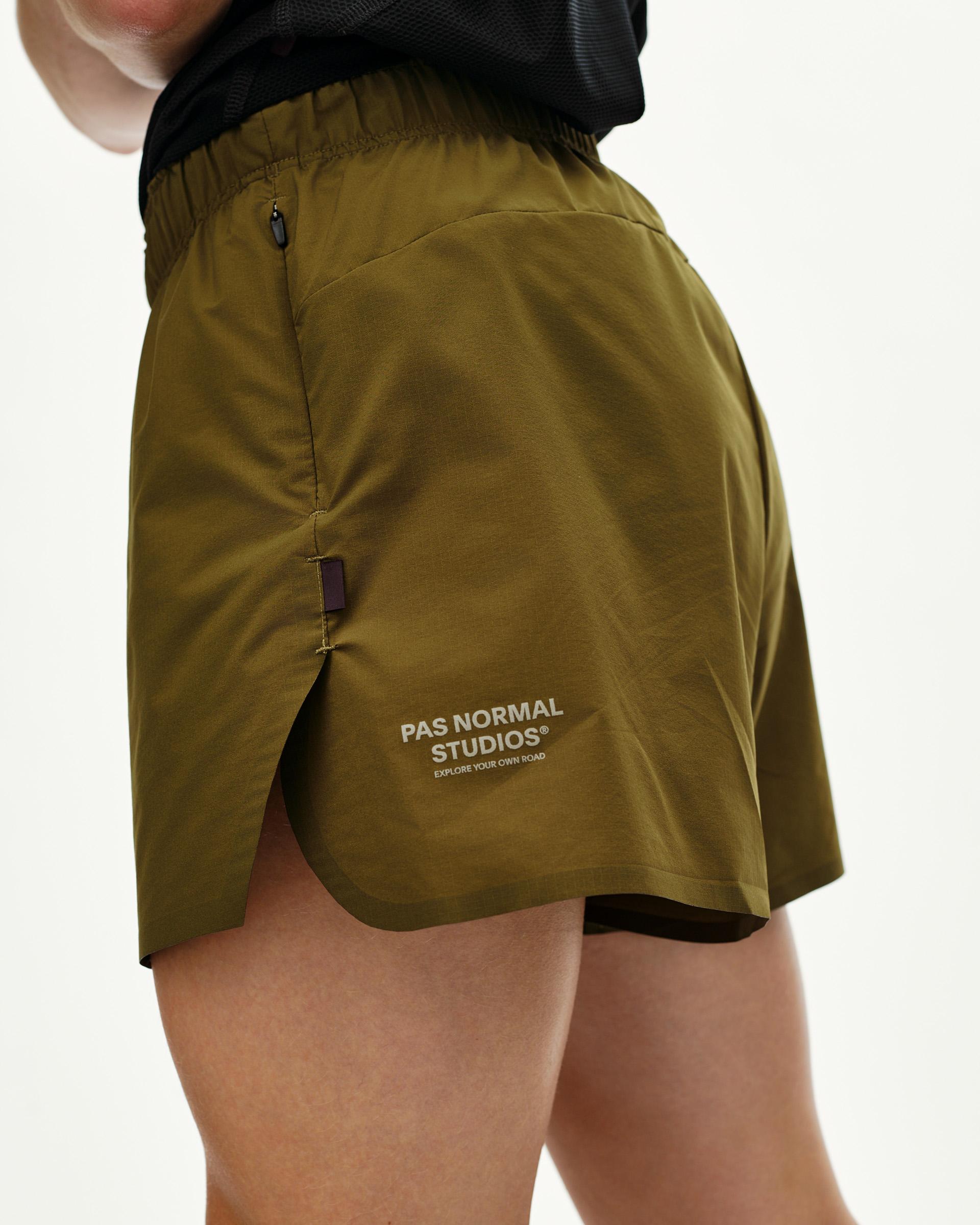 Moss Brown Balance women's shorts, side detail on model with elasticated waistband and zip pocket