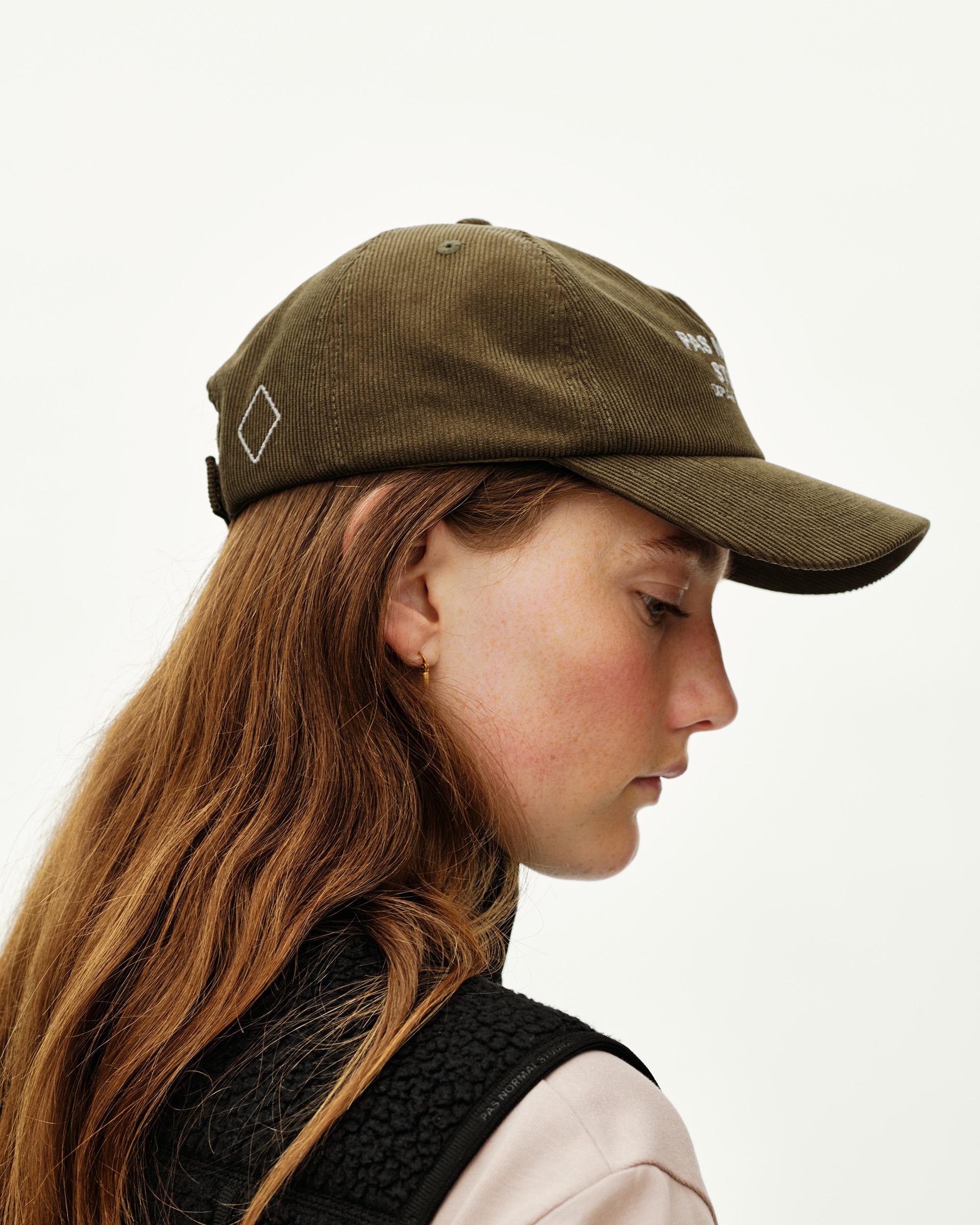 Deep Olive Off-Race Tech Corduroy cap on model, side view with embroidered diamond logo and white text print