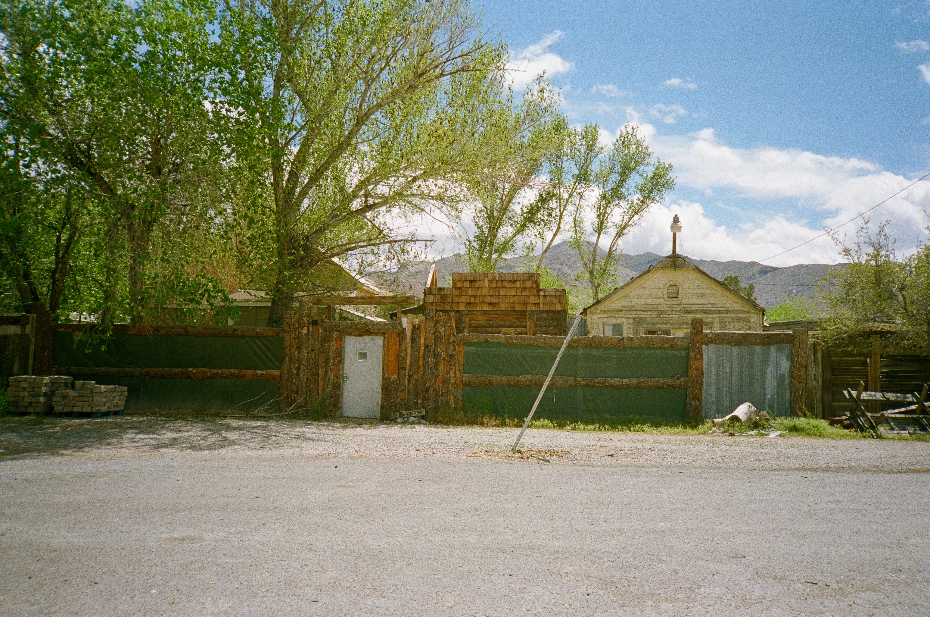 Rural roadside scene with weathered buildings and mountains in Death Valley