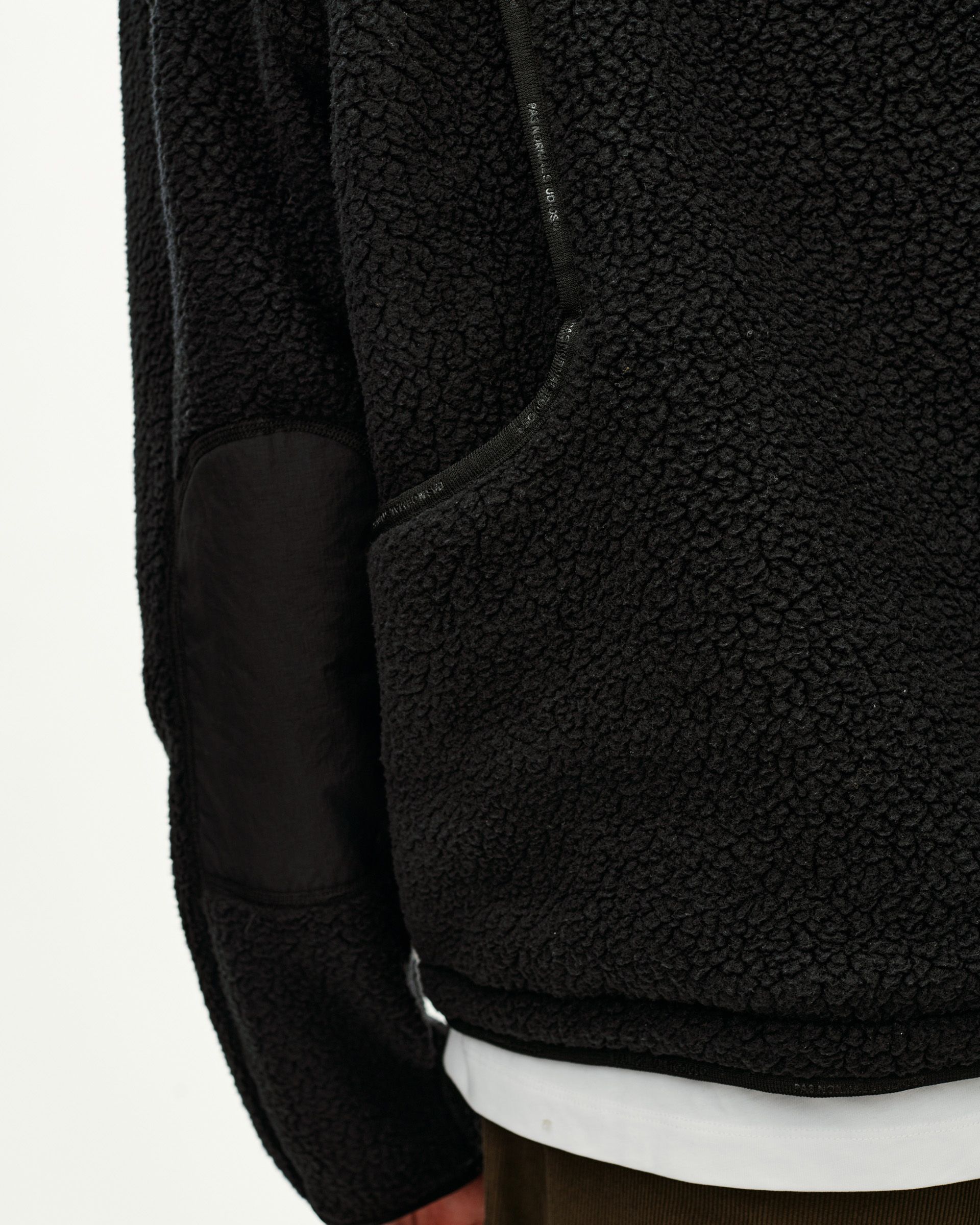 Black Off-Race Pile Fleece jacket, detail view on model showing contrast elbow patch and zip chest pocket