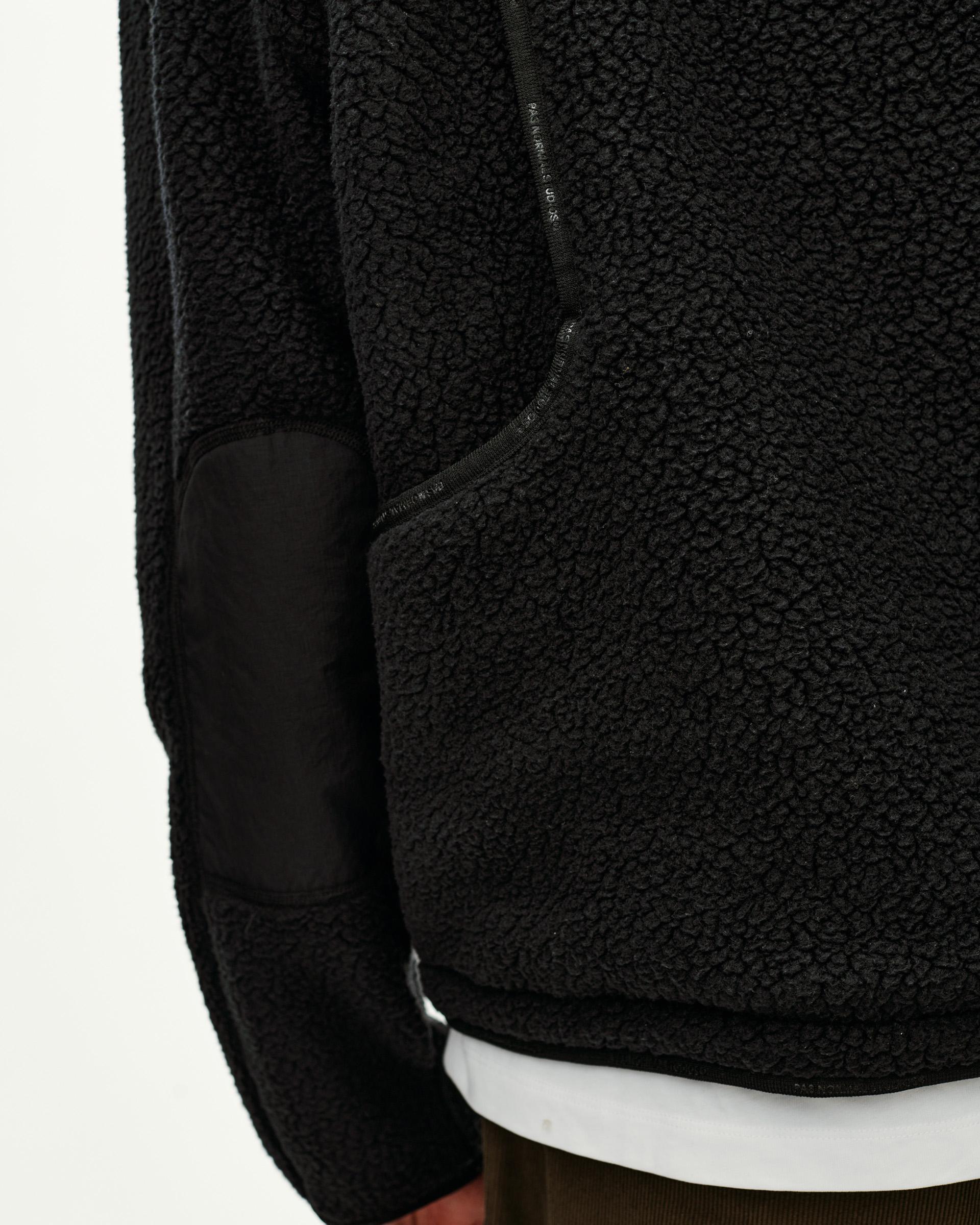 Black Off-Race Pile Fleece jacket, detail view on model showing contrast elbow patch and zip chest pocket