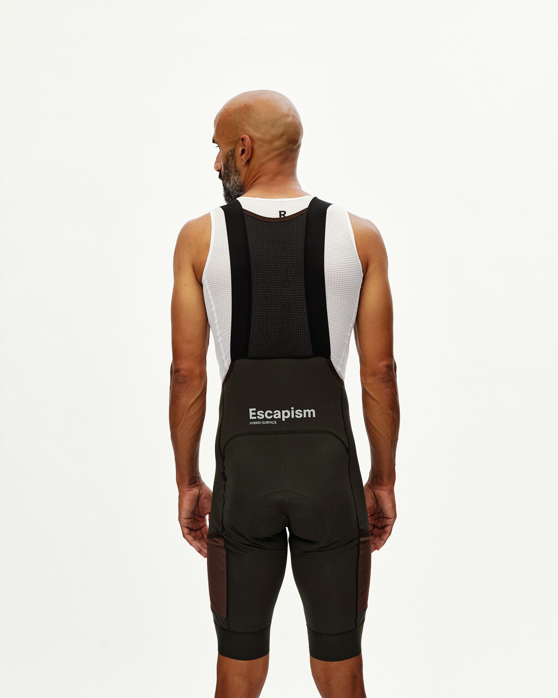 Dark Olive Escapism Cargo cycling bibs on model, rear view with mesh bib straps and white logo print