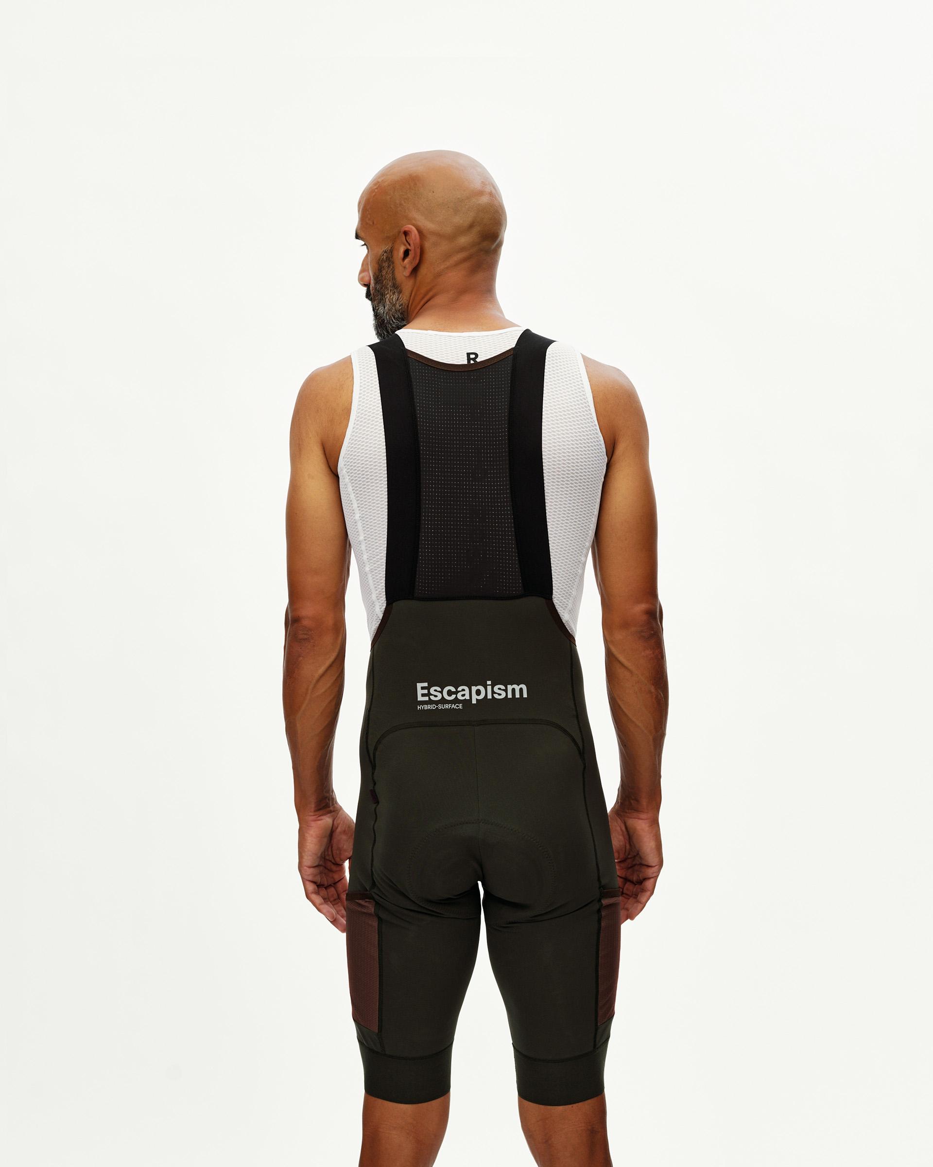 Dark Olive Escapism Cargo cycling bibs on model, rear view with mesh bib straps and white logo print