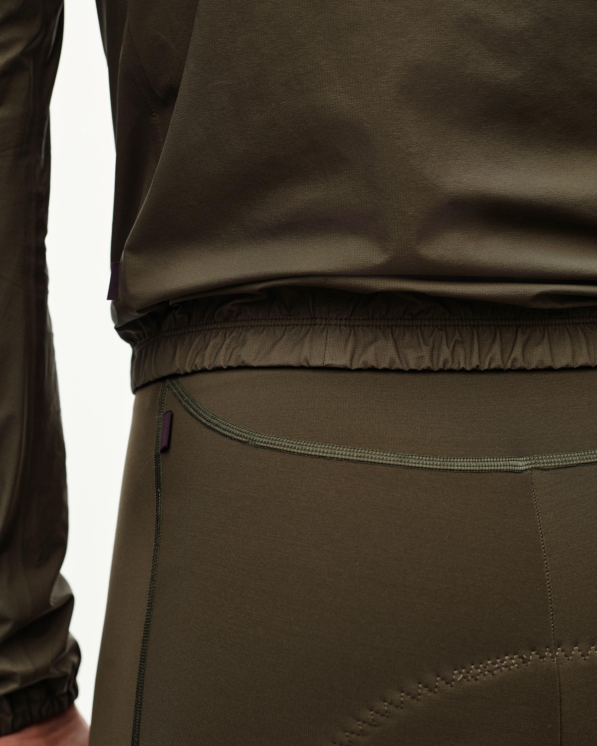 Dark Earth khaki PAS Mechanism Rain jacket, rear detail on model showing elastic hem and bib waistband below