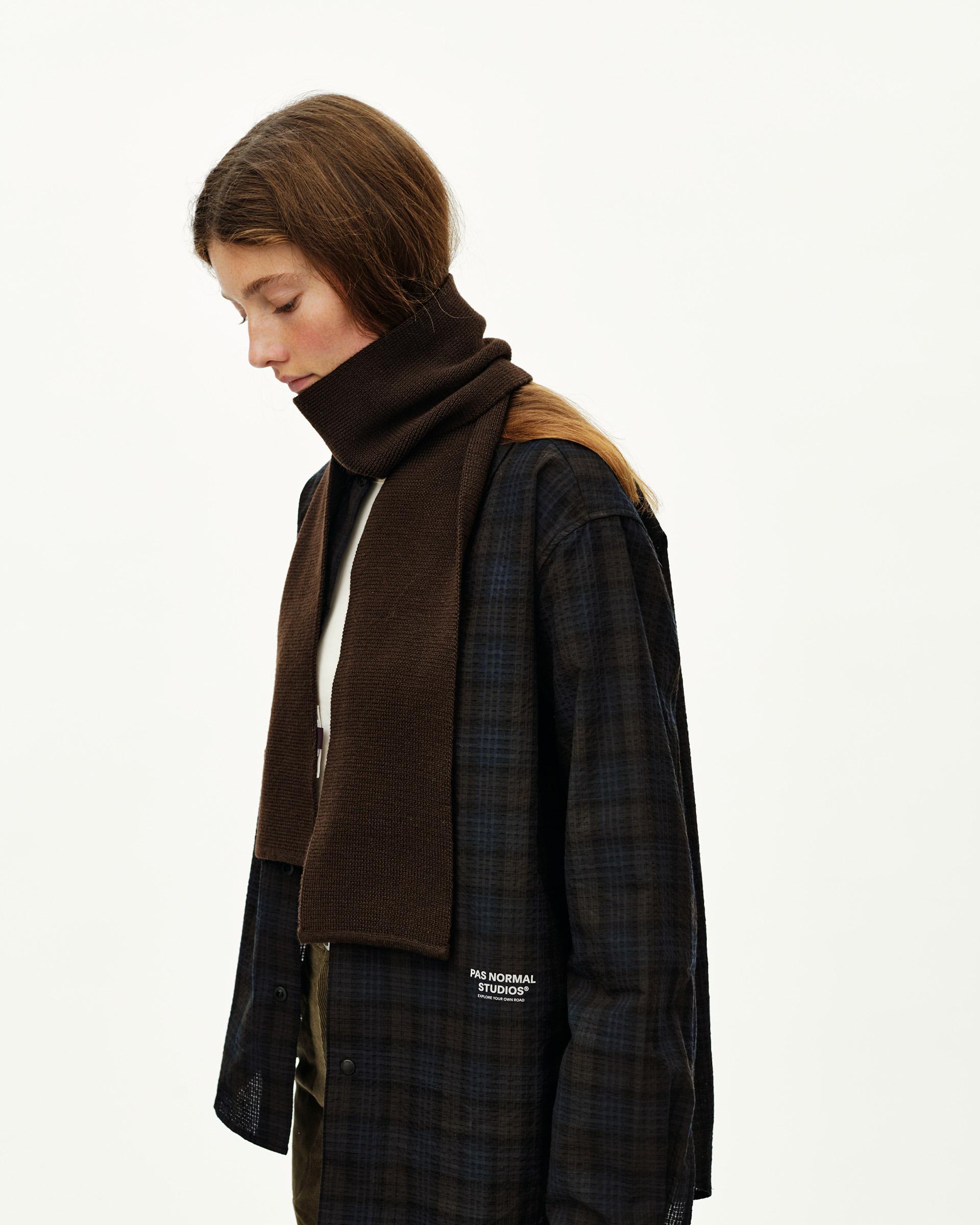 Light Brown Off-Race Wool Knit scarf on model, side view with ribbed knit texture and branded label