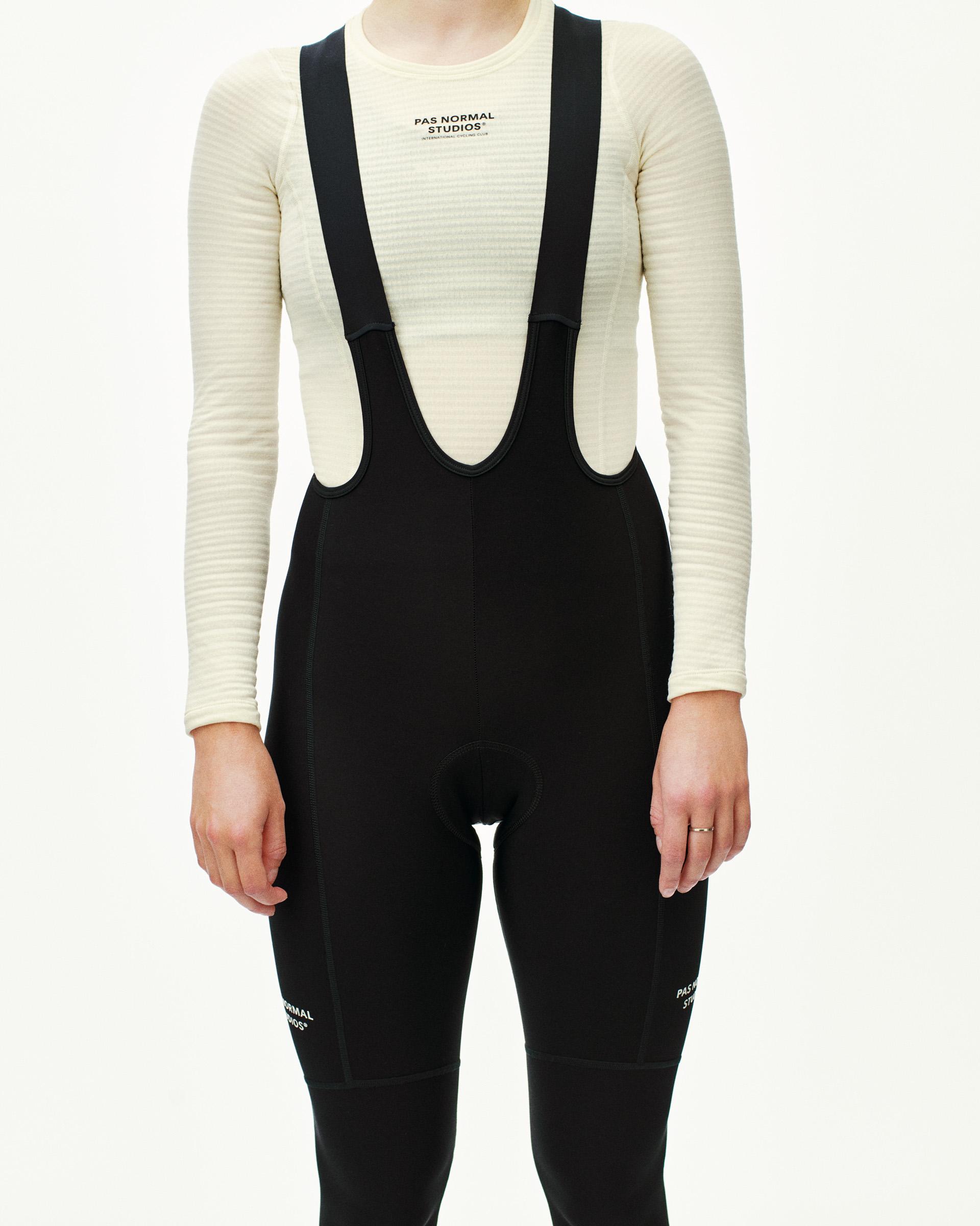Black Essential thermal long cycling bib tights on model, front view with white leg print