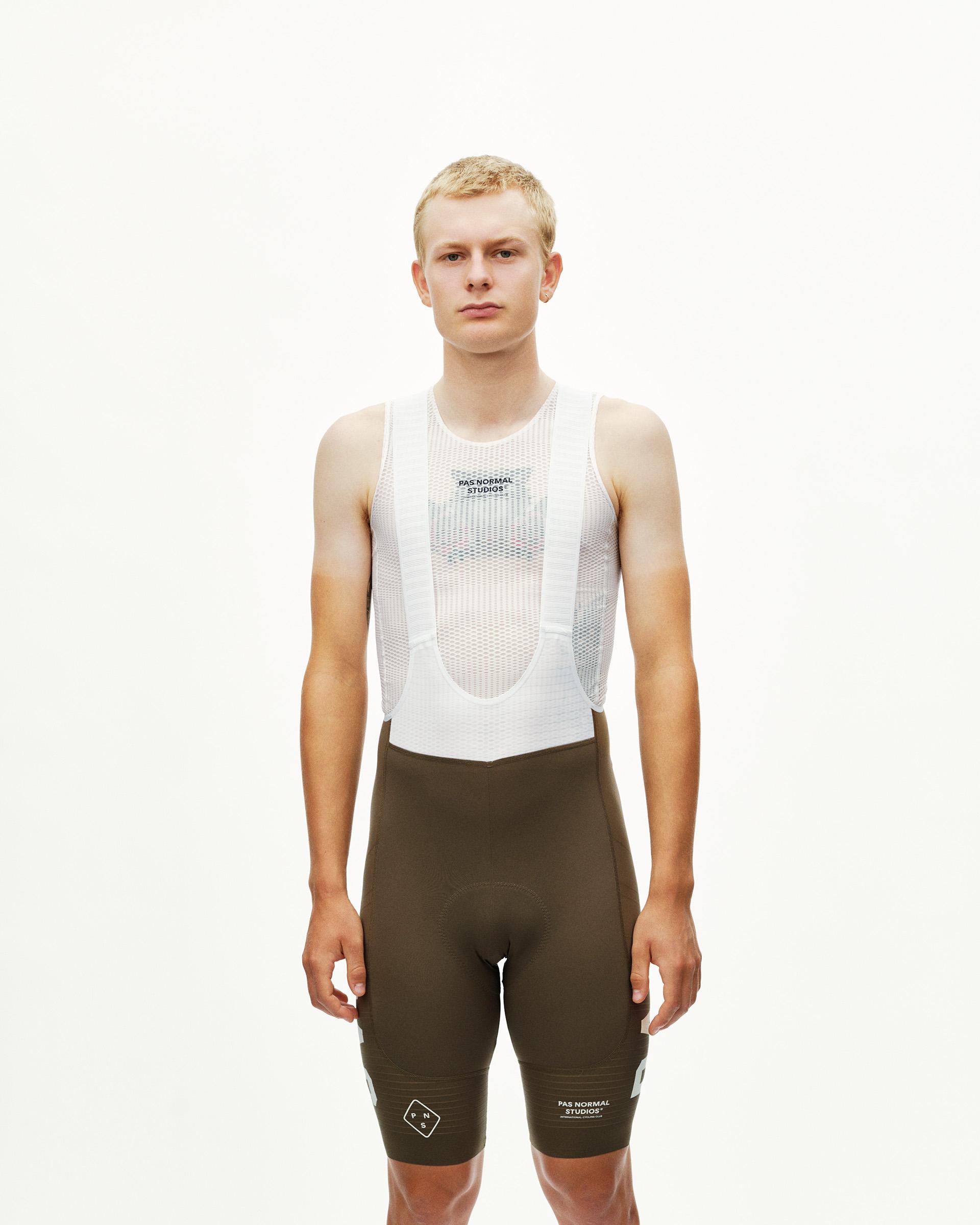 Dark Earth brown PAS Mechanism Pro cycling bibs on model, front view with white mesh bib straps