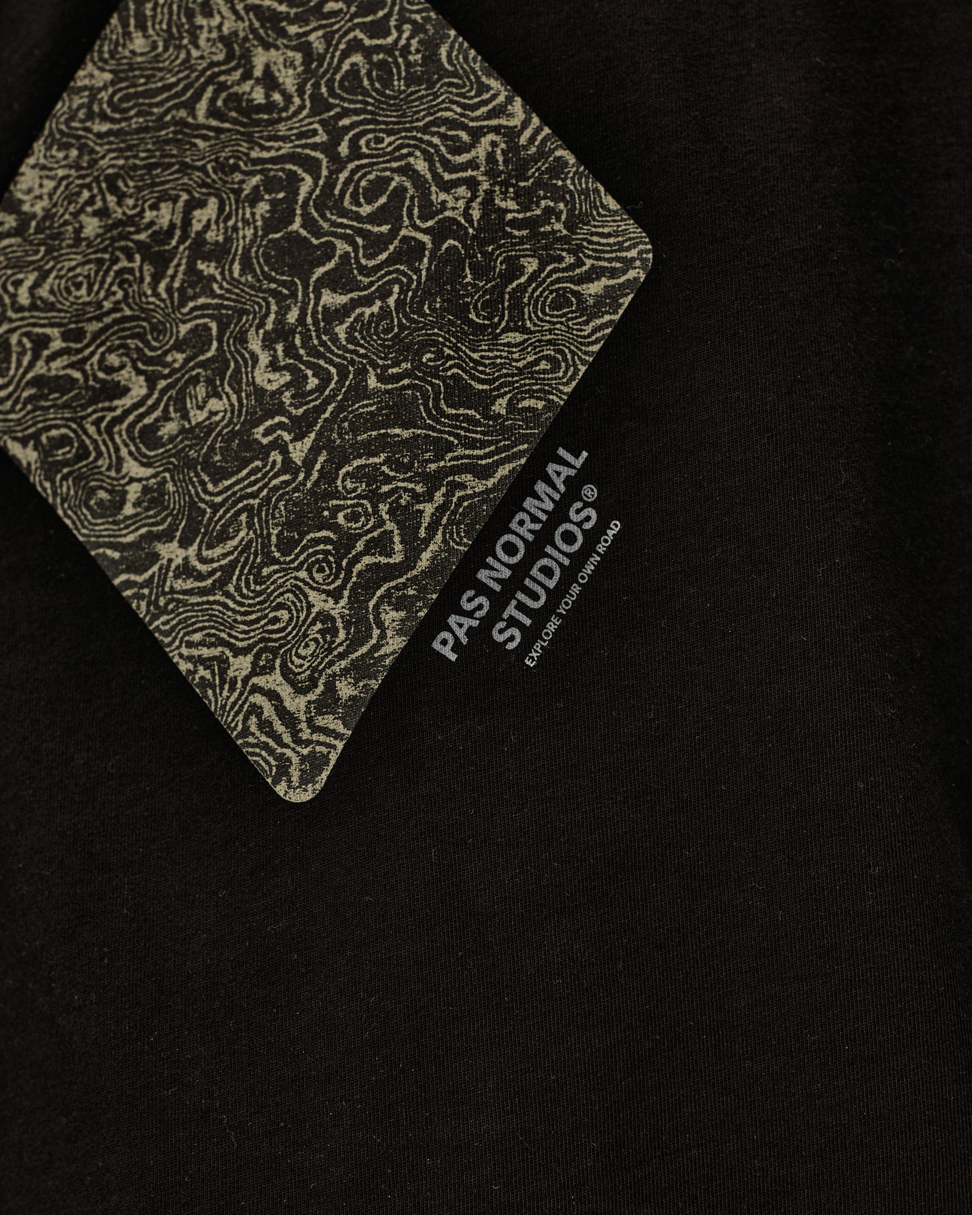 Black Off-Race Graphic T-Shirt, detail view showing topographic map print label card against black fabric