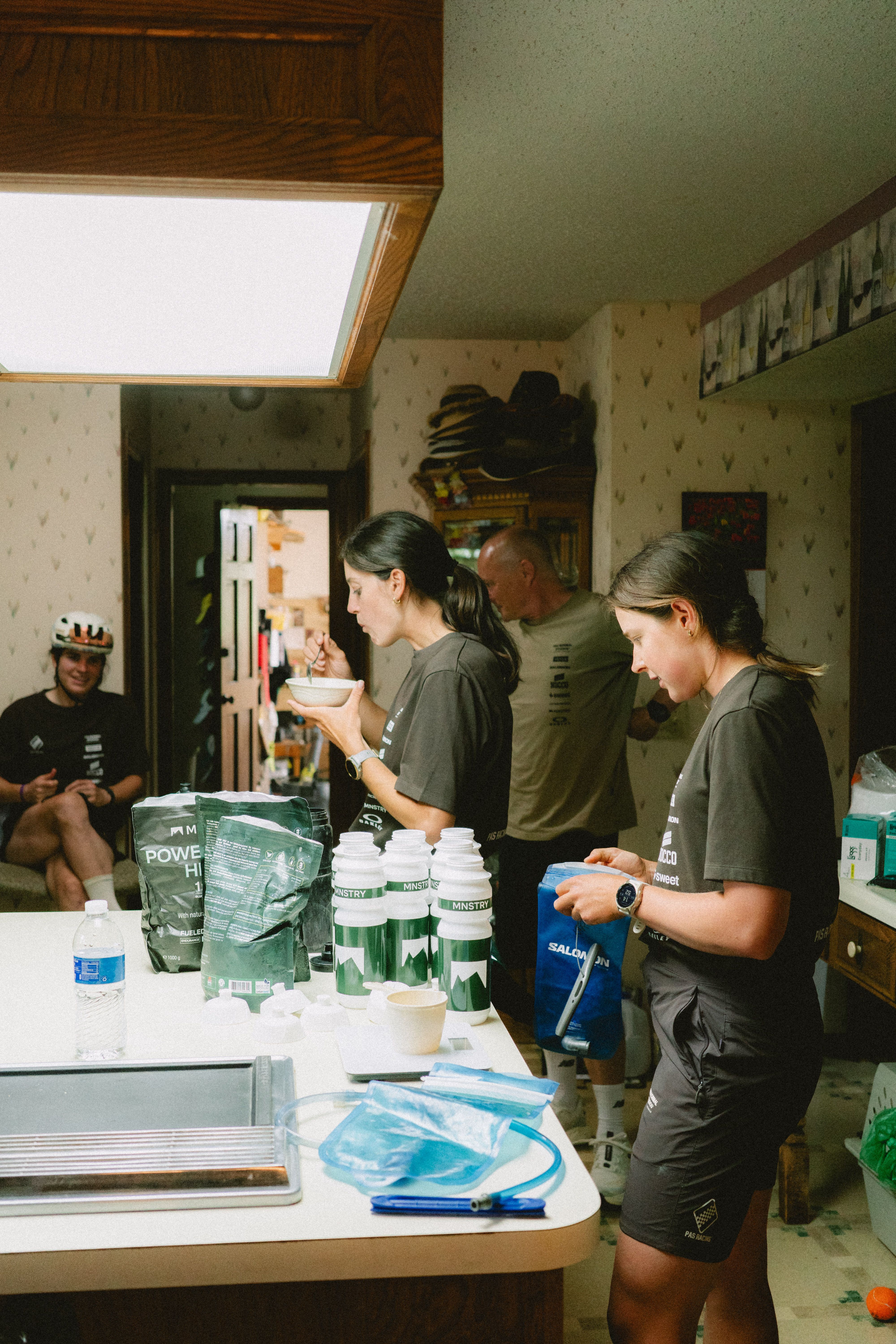 Cyclists preparing nutrition in kitchen wearing green jerseys and shorts