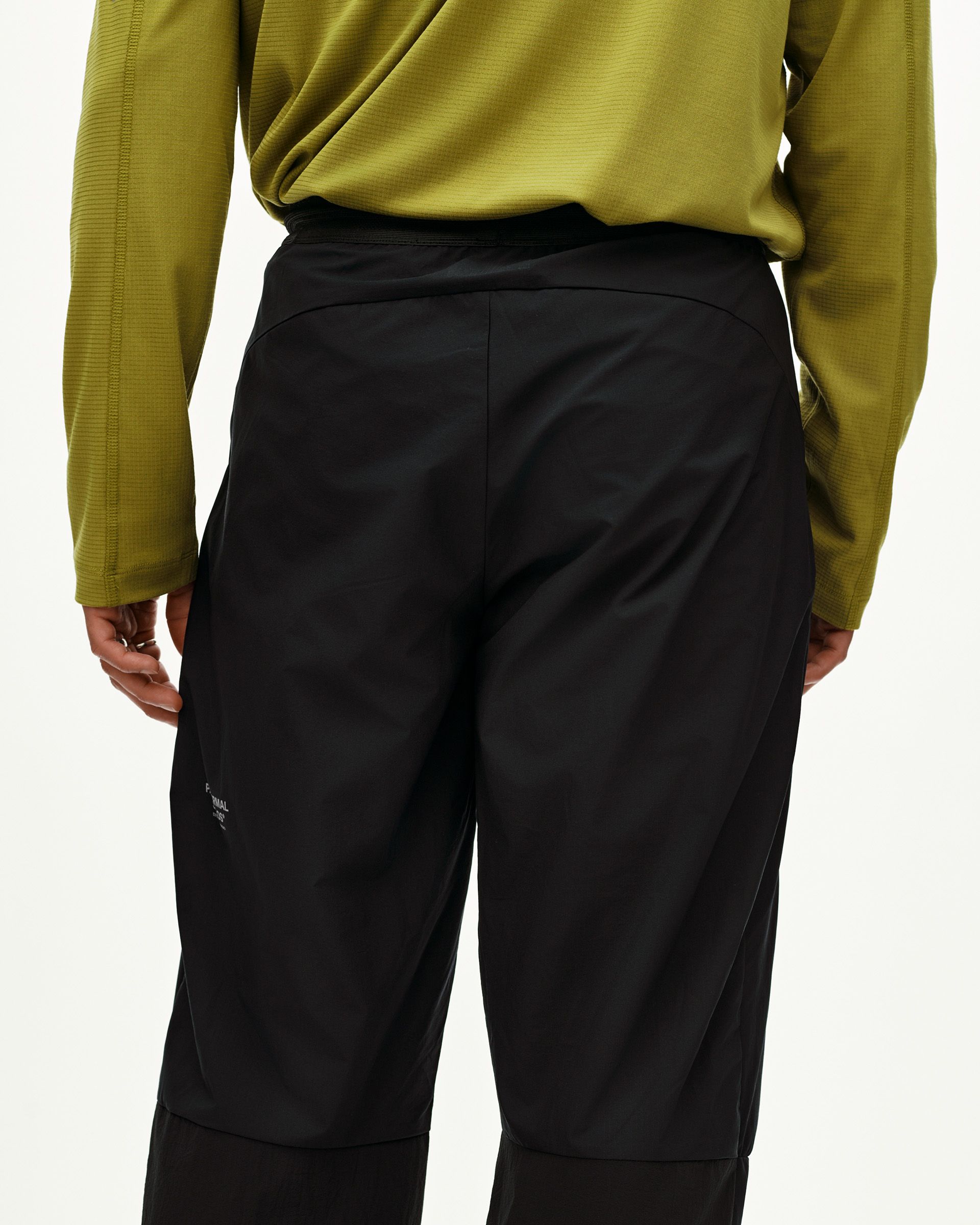 Black Balance Performance Pants on model, rear view with elastic waistband and panel seaming