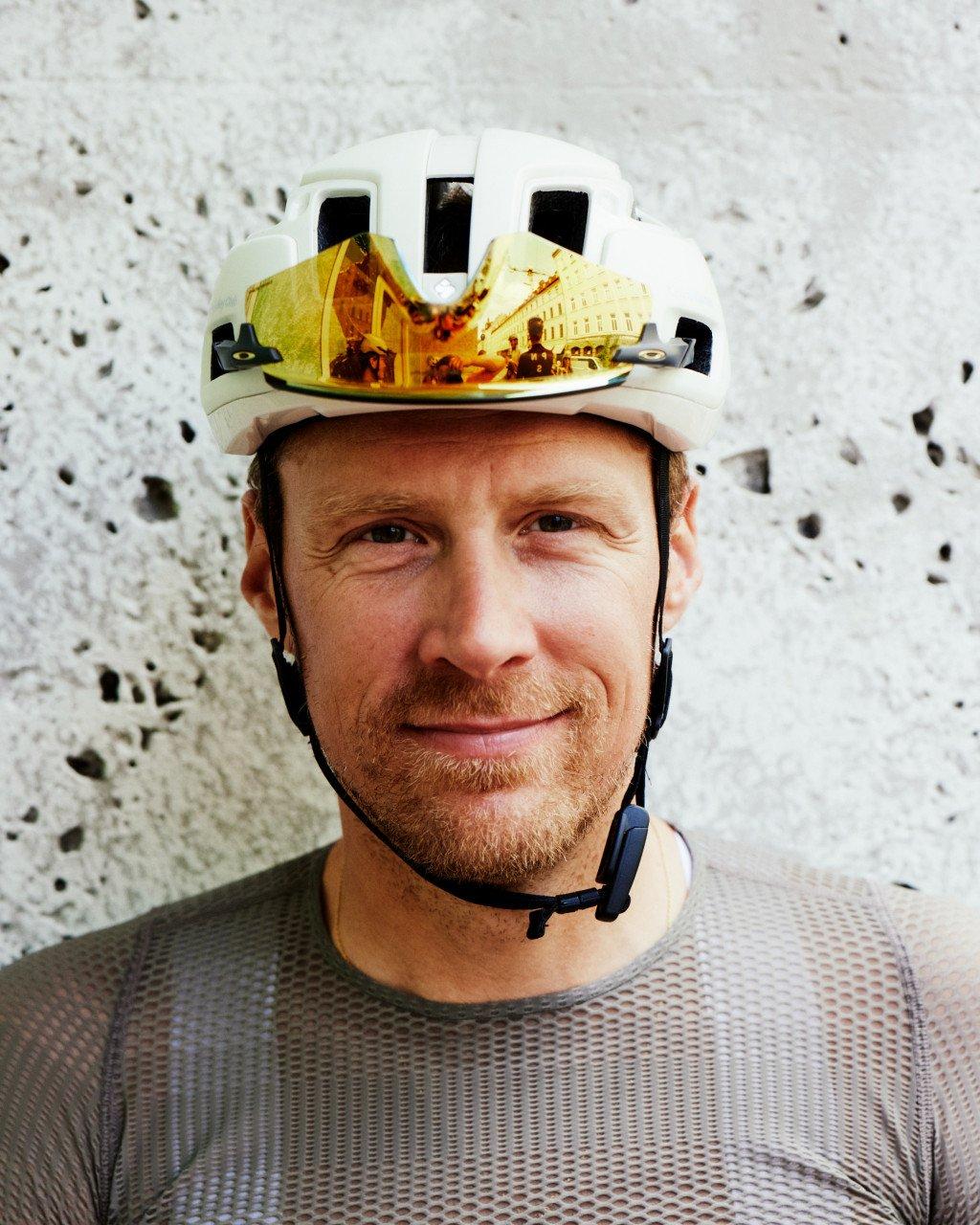 Model wearing white cycling helmet with reflective visor and grey textured base layer