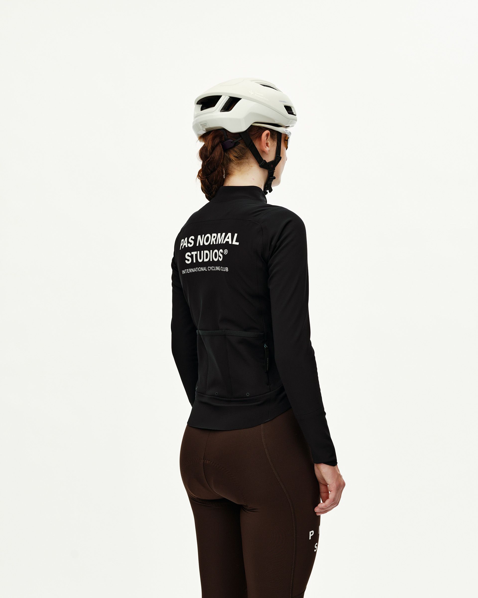 Black Mechanism Thermal women's cycling jacket on model, rear view with white back logo print and rear pockets