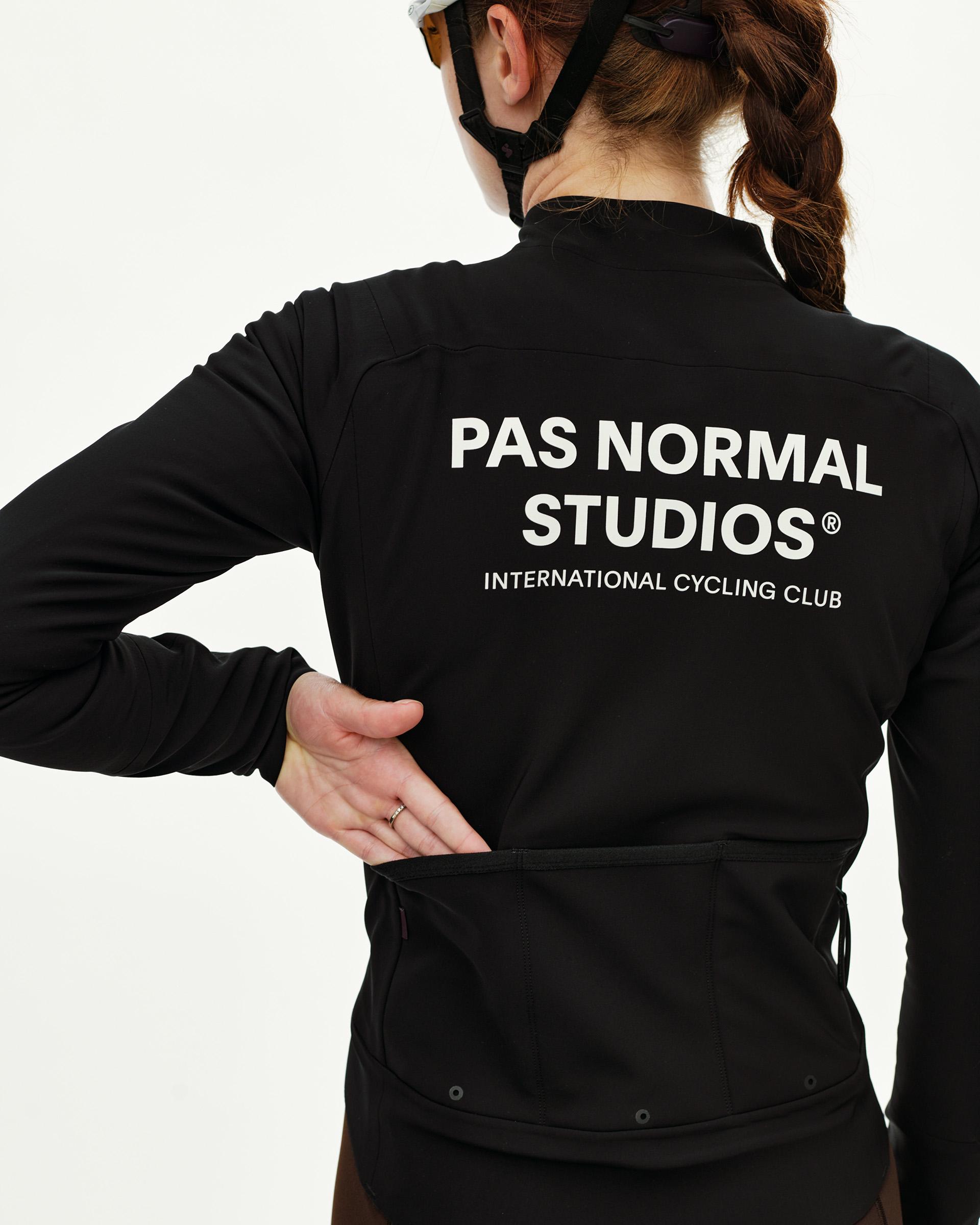 Black Mechanism Thermal cycling jacket on model, rear view with white back print and rear pockets