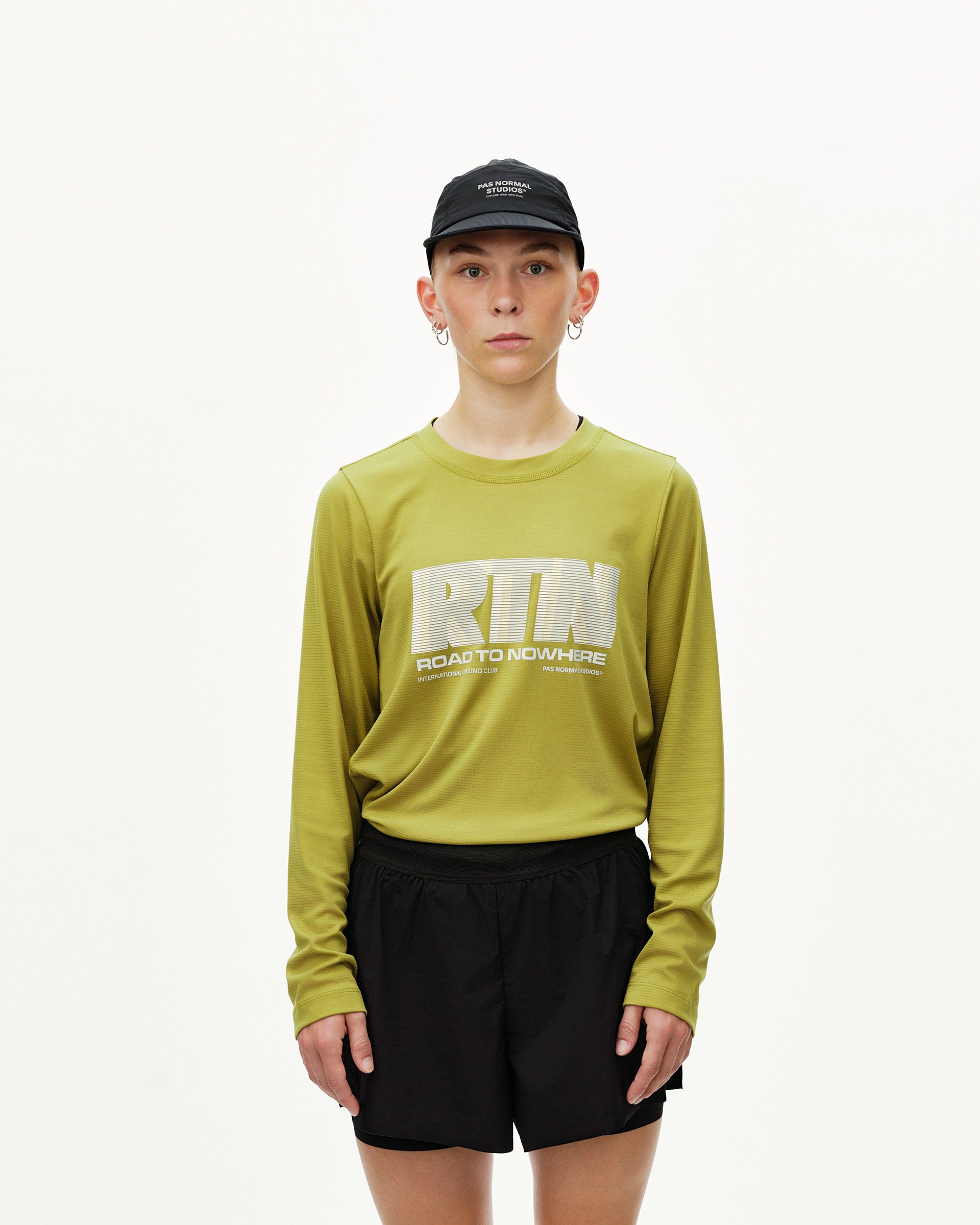 Black Balance 2-in-1 shorts on model, front view — paired with yellow-green long sleeve top with RTN chest print