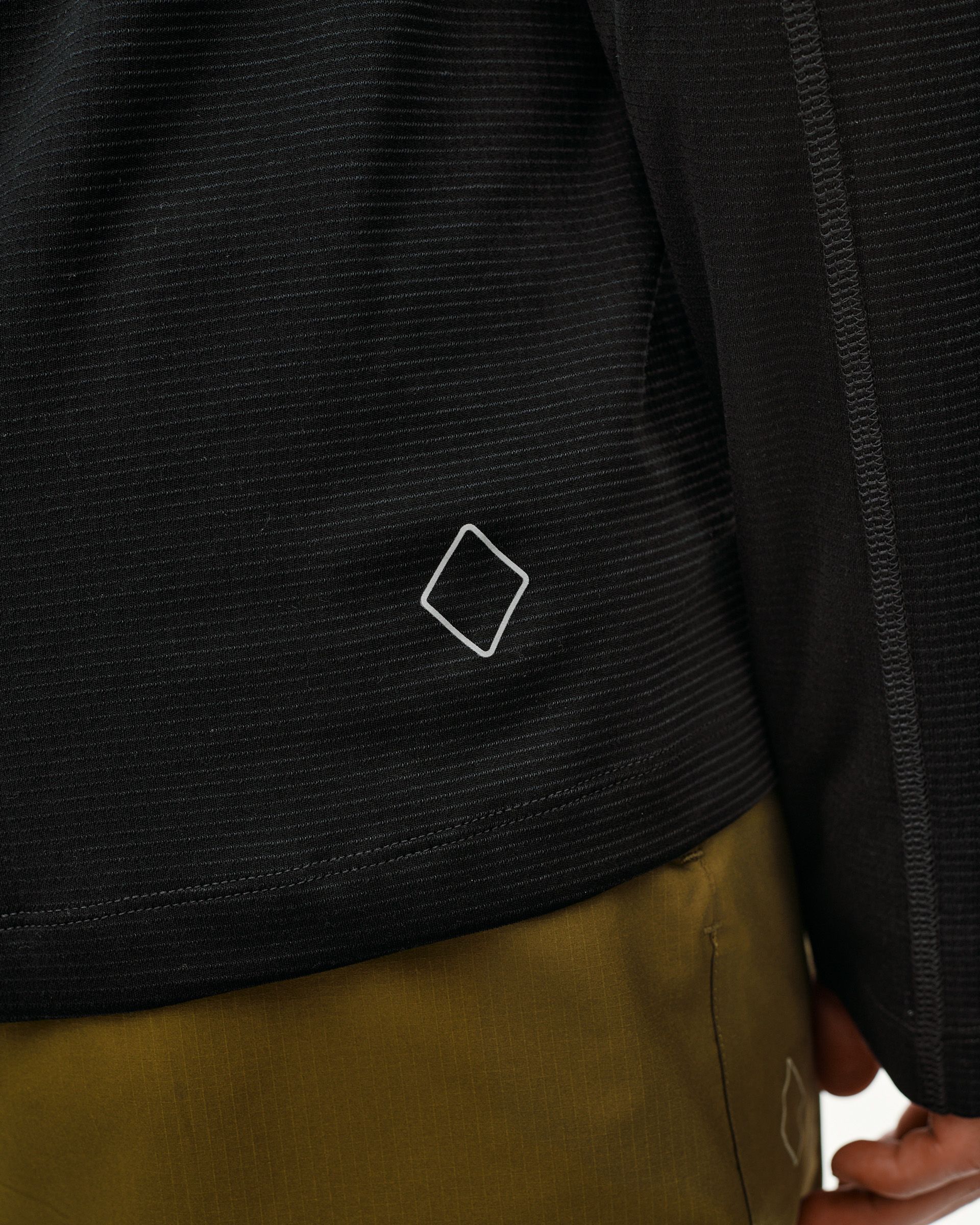 Black Balance long sleeve T-shirt, detail view on model showing diamond logo and ribbed texture