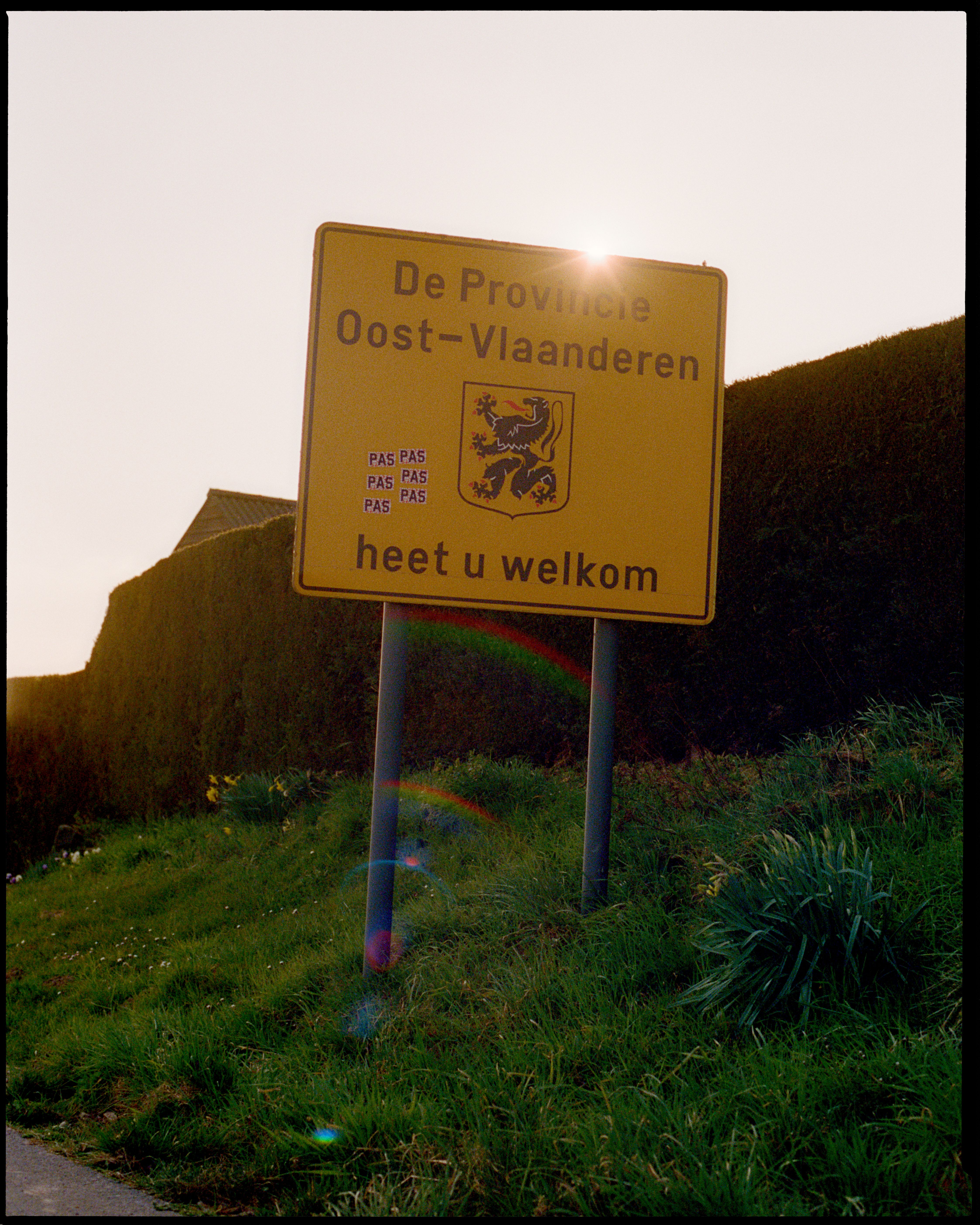 Yellow road sign welcoming visitors to East Flanders province with logo branding