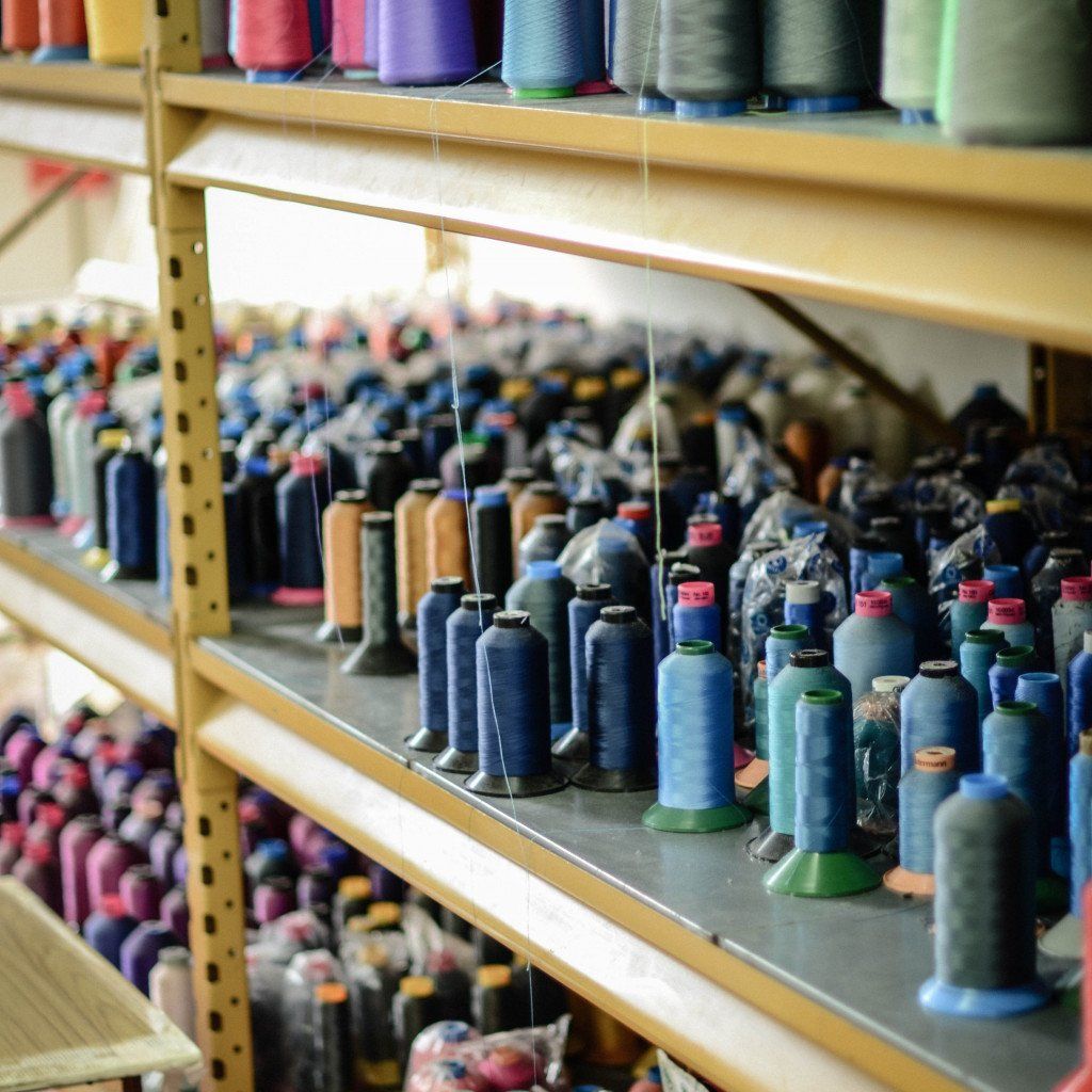 Colorful thread spools organized on shelves in textile manufacturing facility