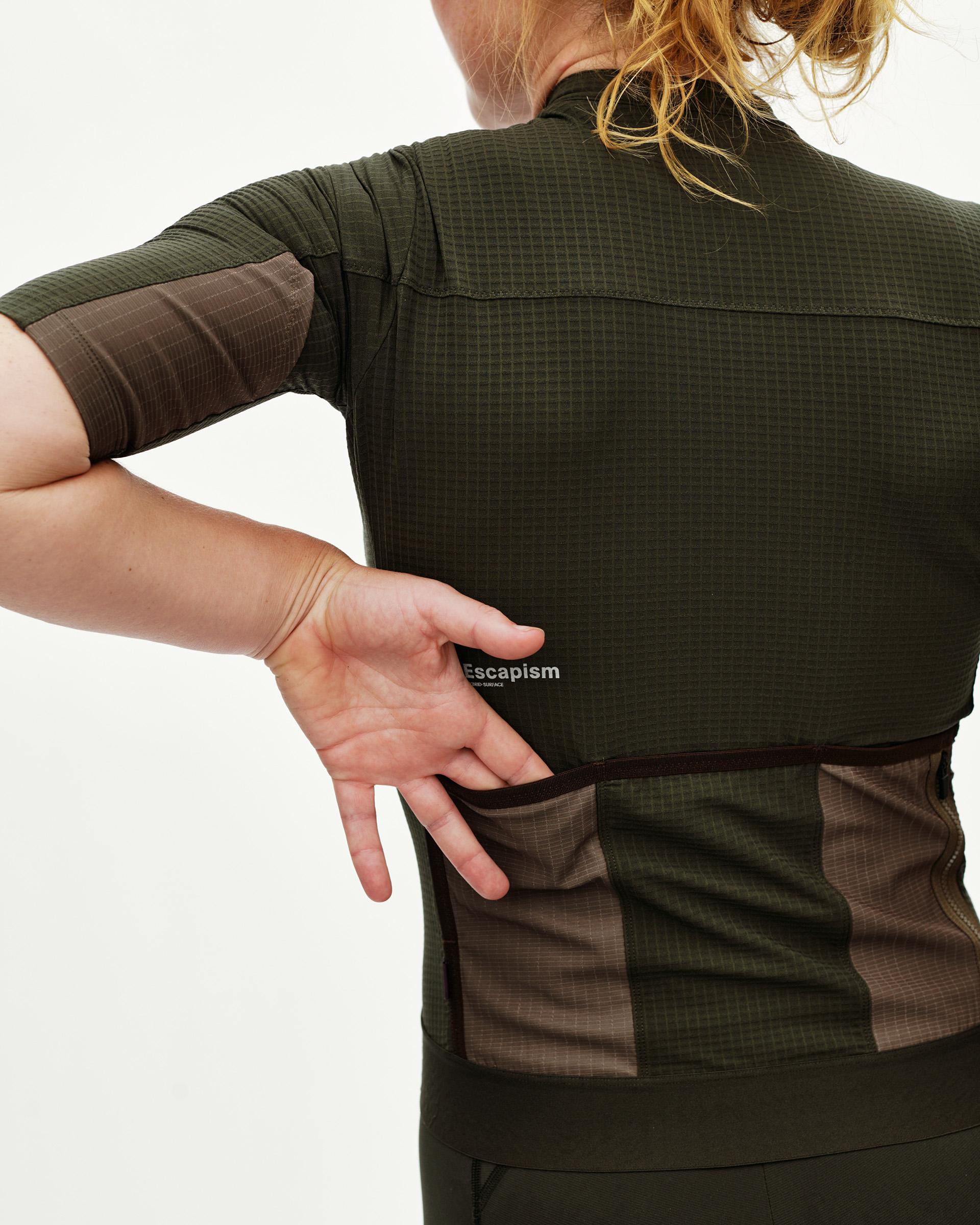 Dark Olive Escapism women's cycling jersey, rear view on model showing back pockets and two-tone ripstop panels