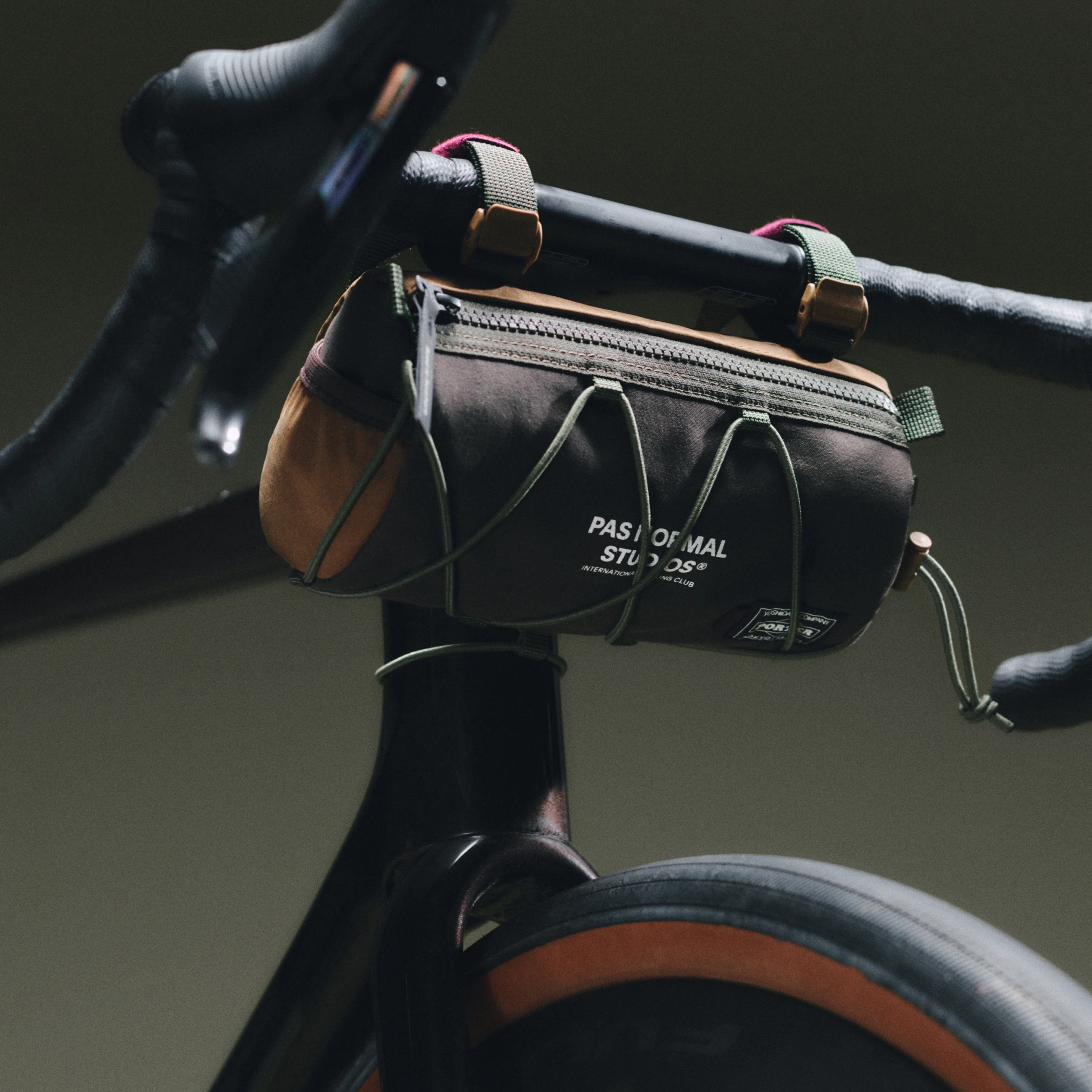 Black Porter-Yoshida handlebar bag mounted on road bike stem, front view with bungee cords and top zip