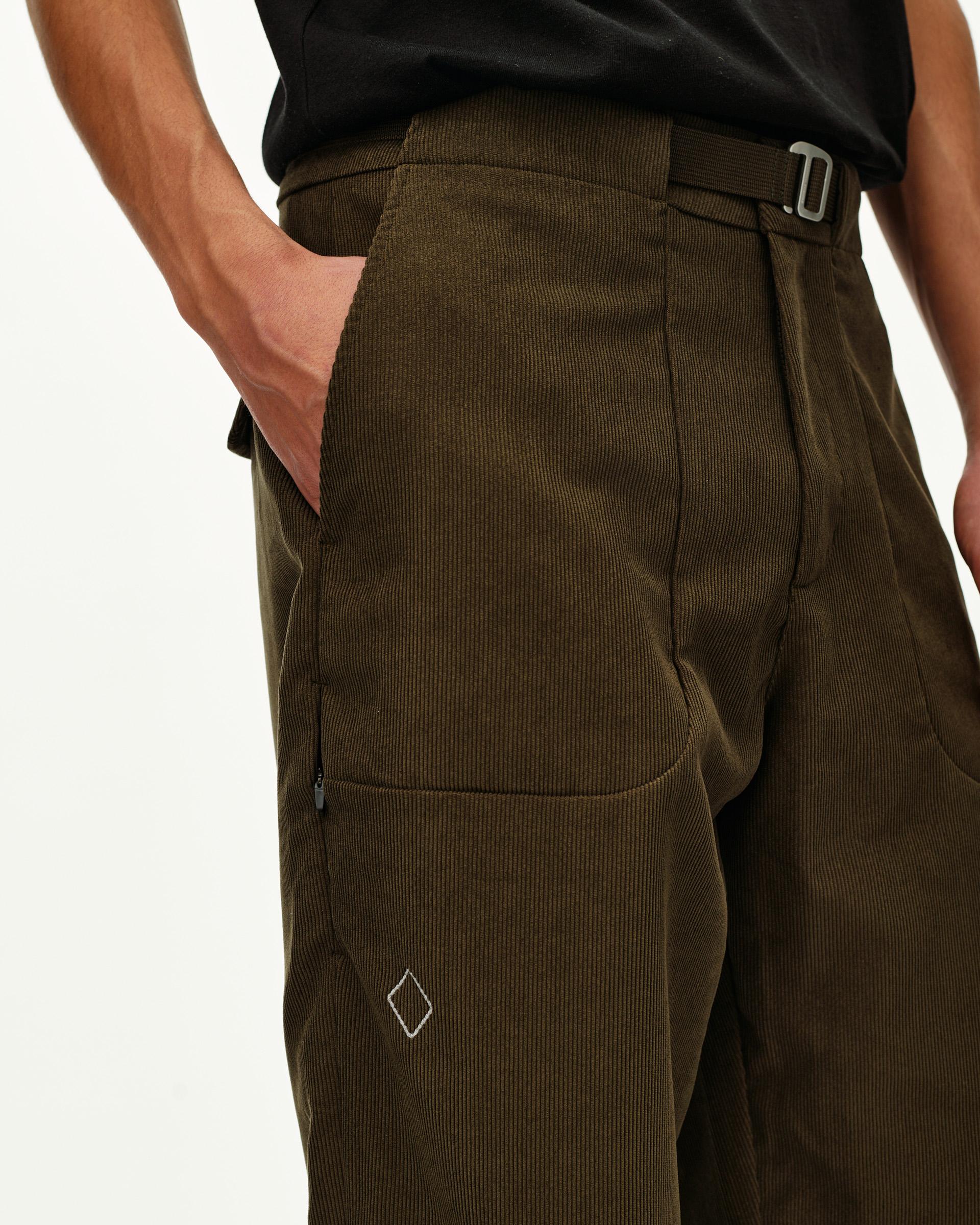 Deep Olive Off-Race Corduroy pants, side detail on model with buckle waistband and diamond logo embroidery