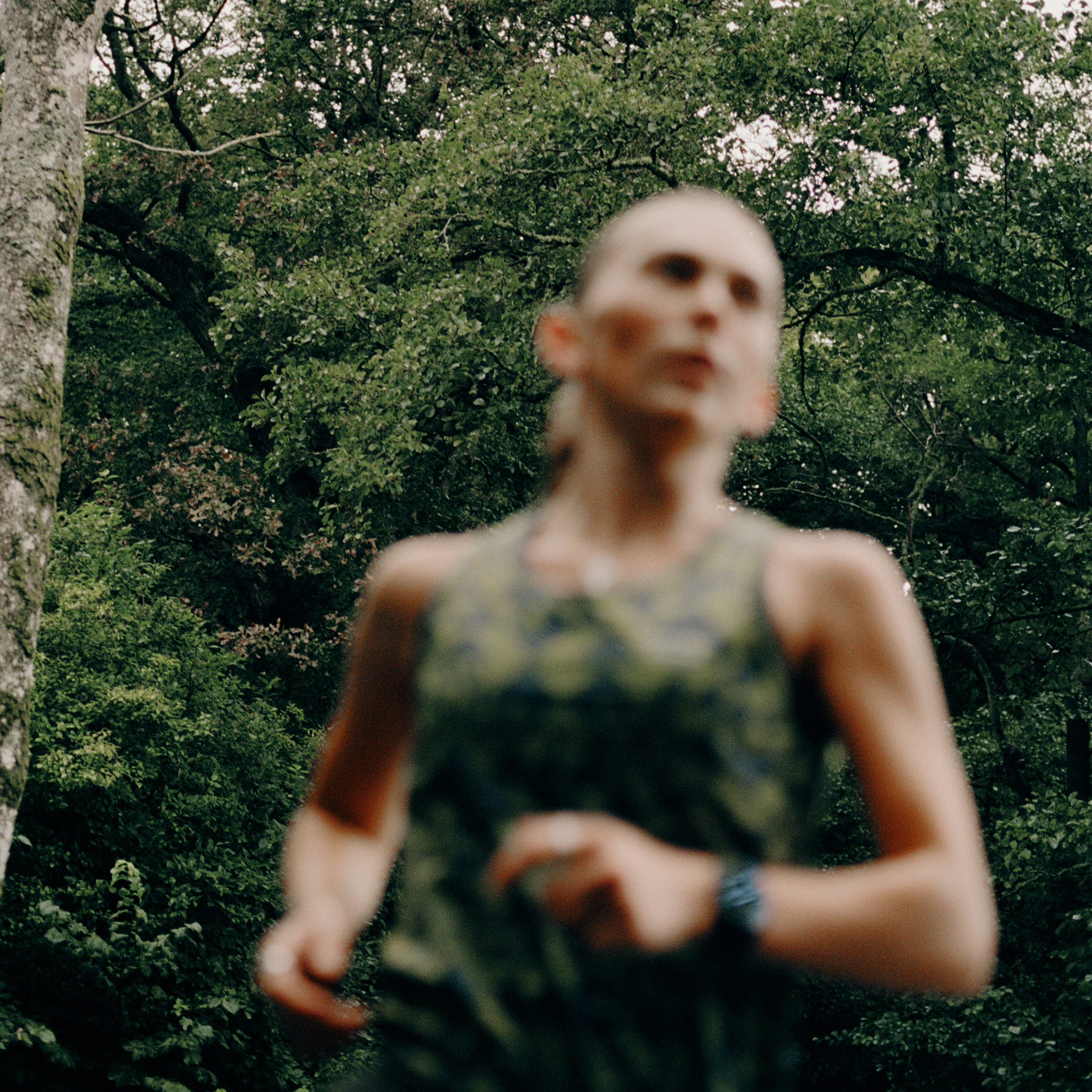 Model wearing Balance collection cycling apparel in motion blur against green foliage background