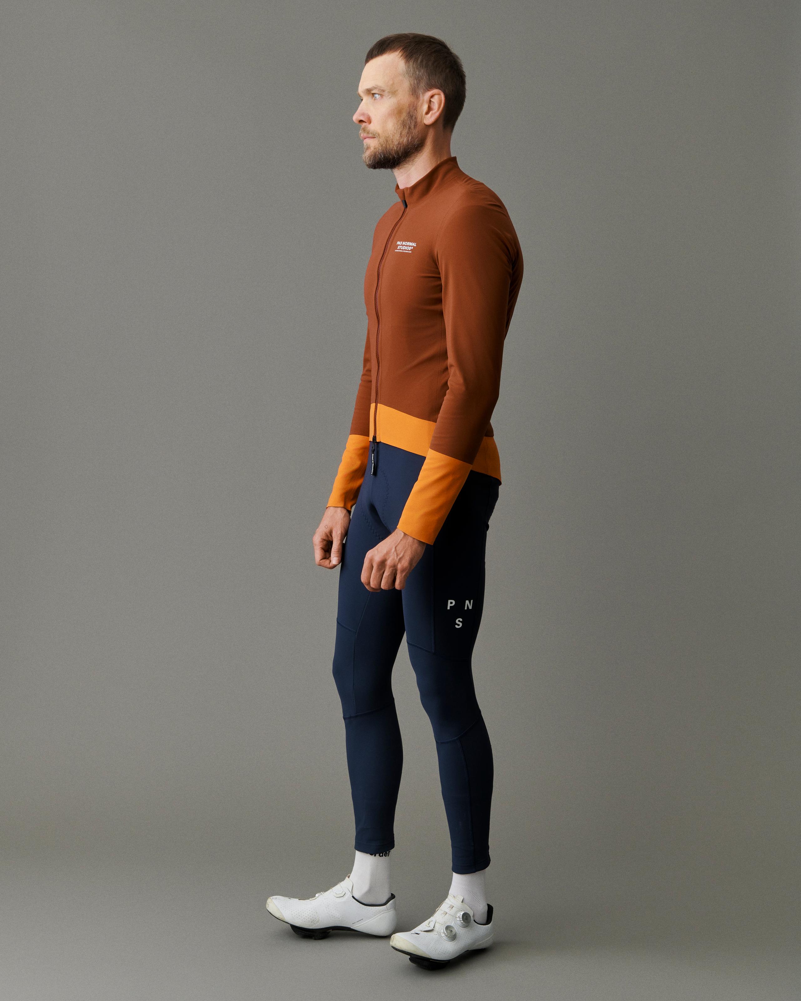 Brown Mechanism Thermal cycling jacket on model, side view with orange color-block panels