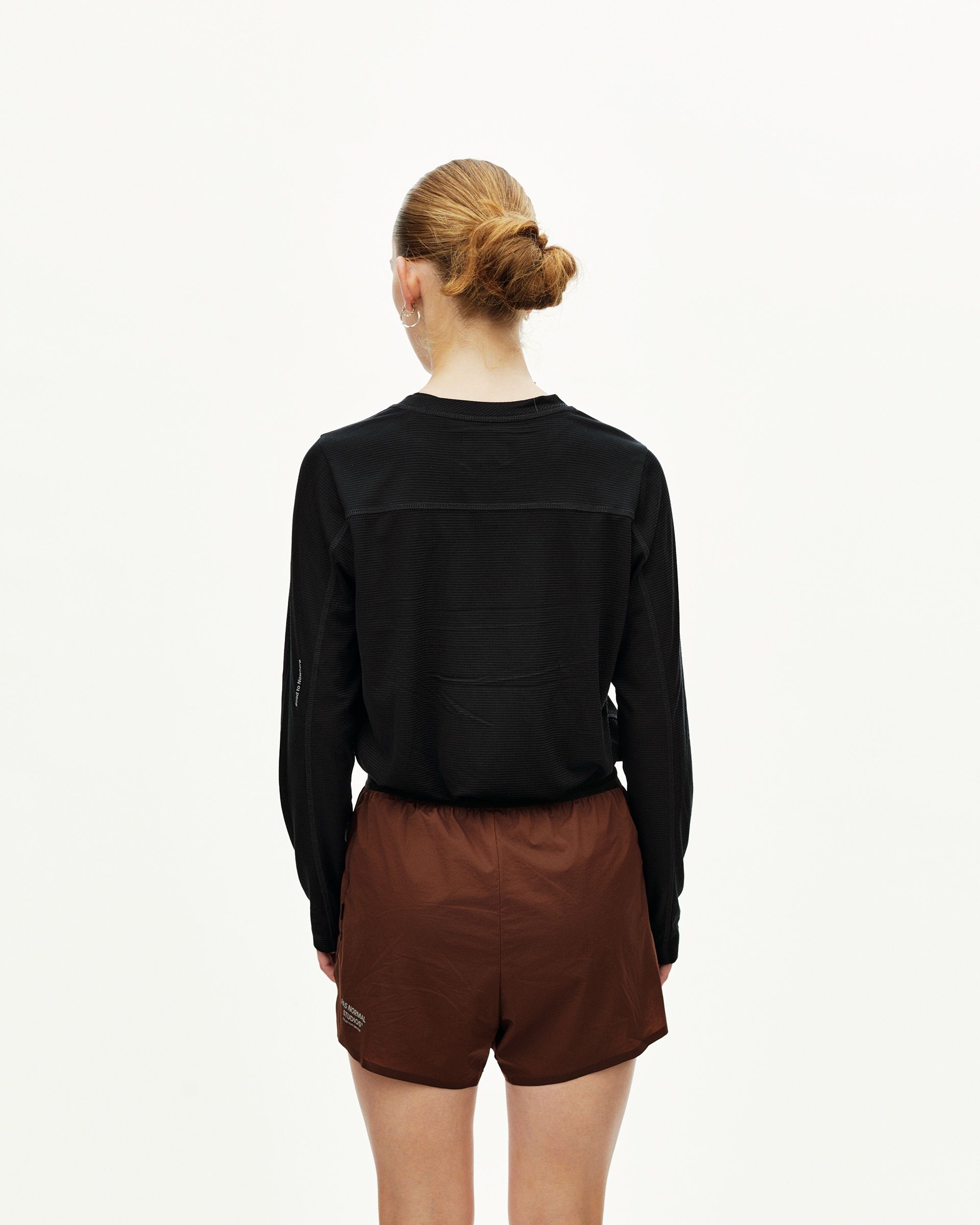 Maroon Brown Balance 2-in-1 shorts on model, rear view with elastic waistband and logo print