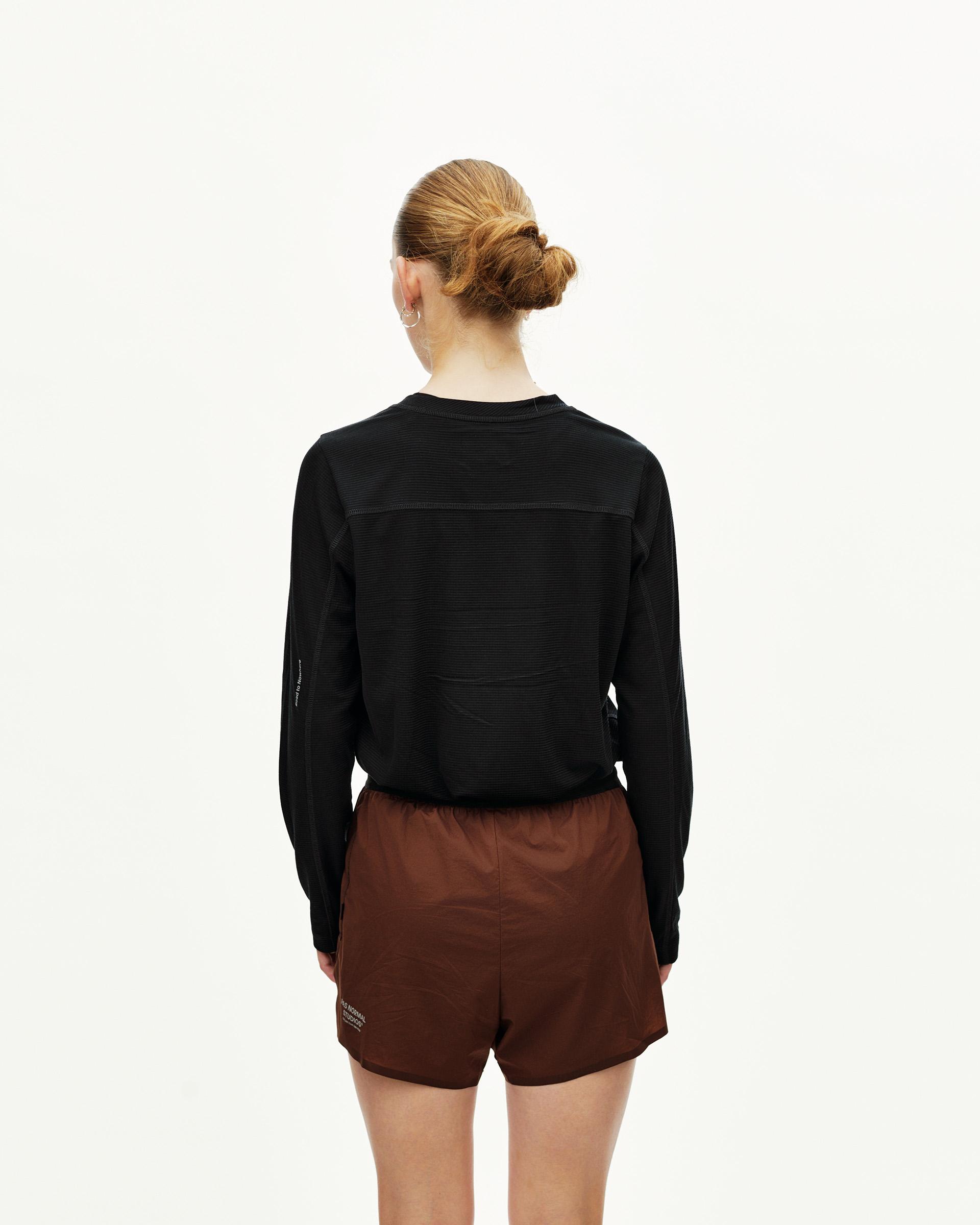 Maroon Brown Balance 2-in-1 shorts on model, rear view with elastic waistband and logo print