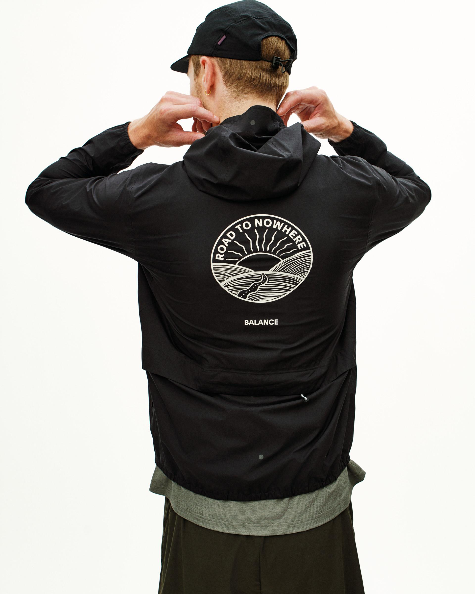Black Balance Rain jacket, rear view on model with white Road to Nowhere circular back print