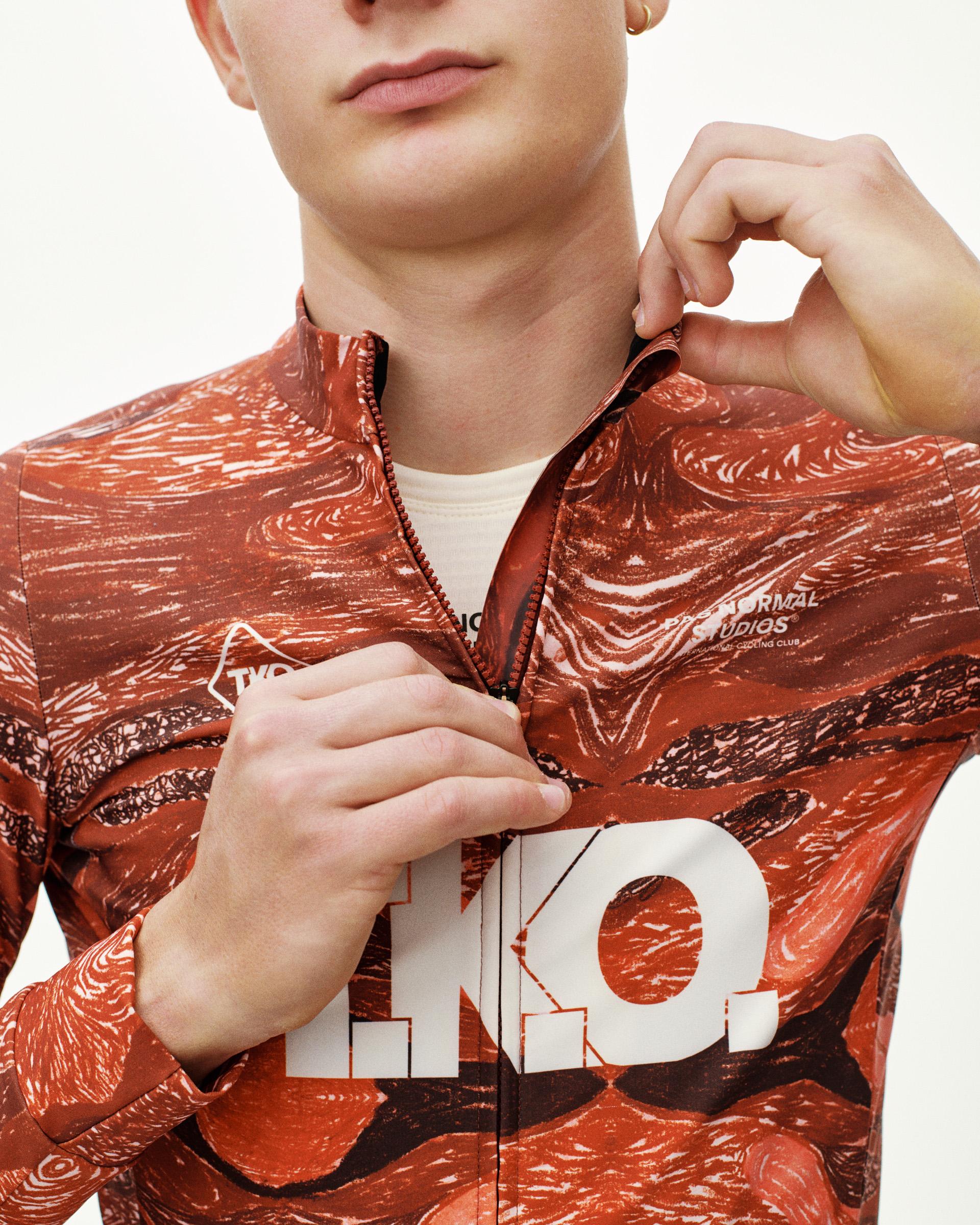 Red T.K.O. cycling long sleeve jersey on model, front detail view with allover print and T.K.O. chest graphic