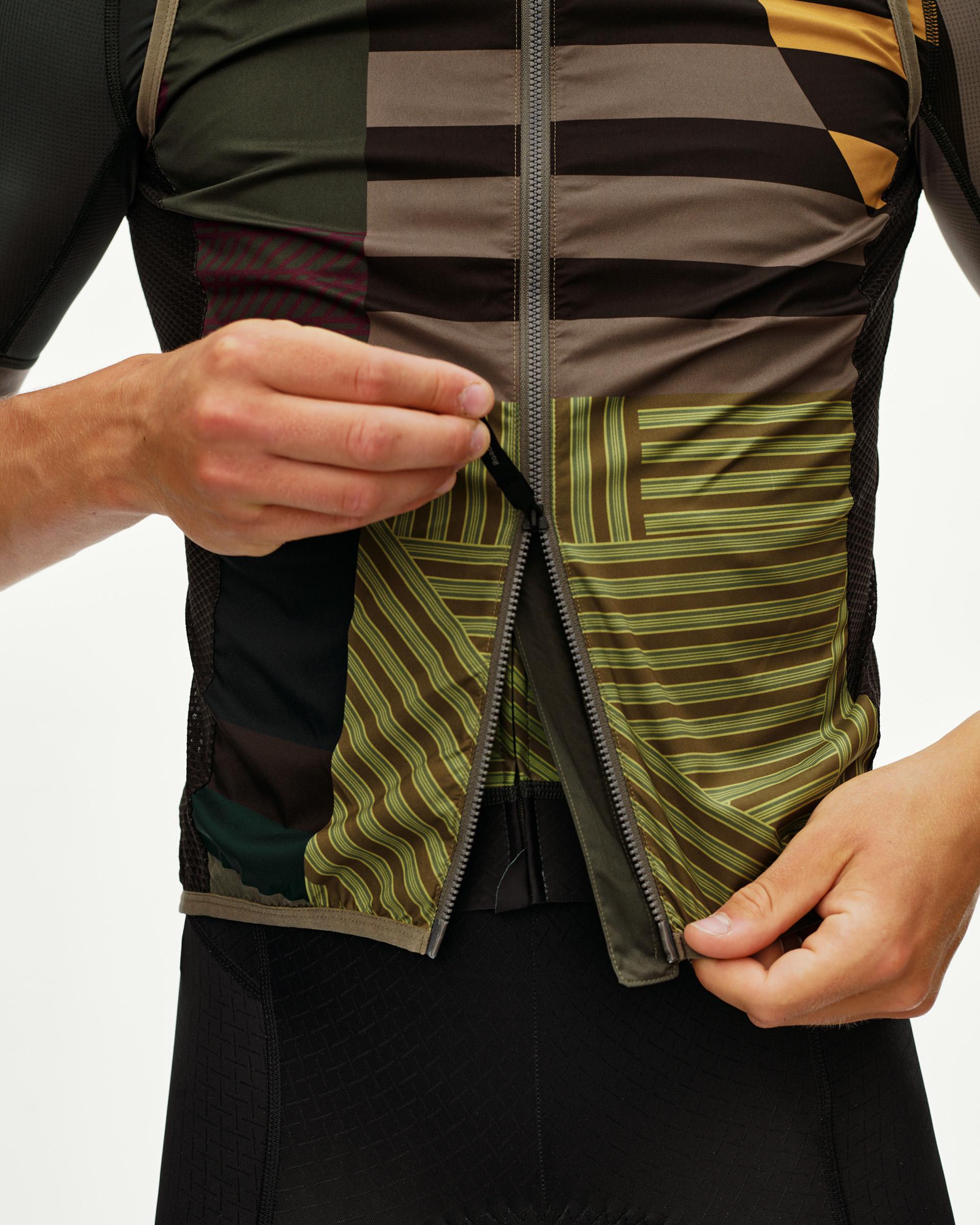 Dusty Earth khaki Mechanism Stow Away cycling gilet, front detail on model with open zip and graphic stripe print