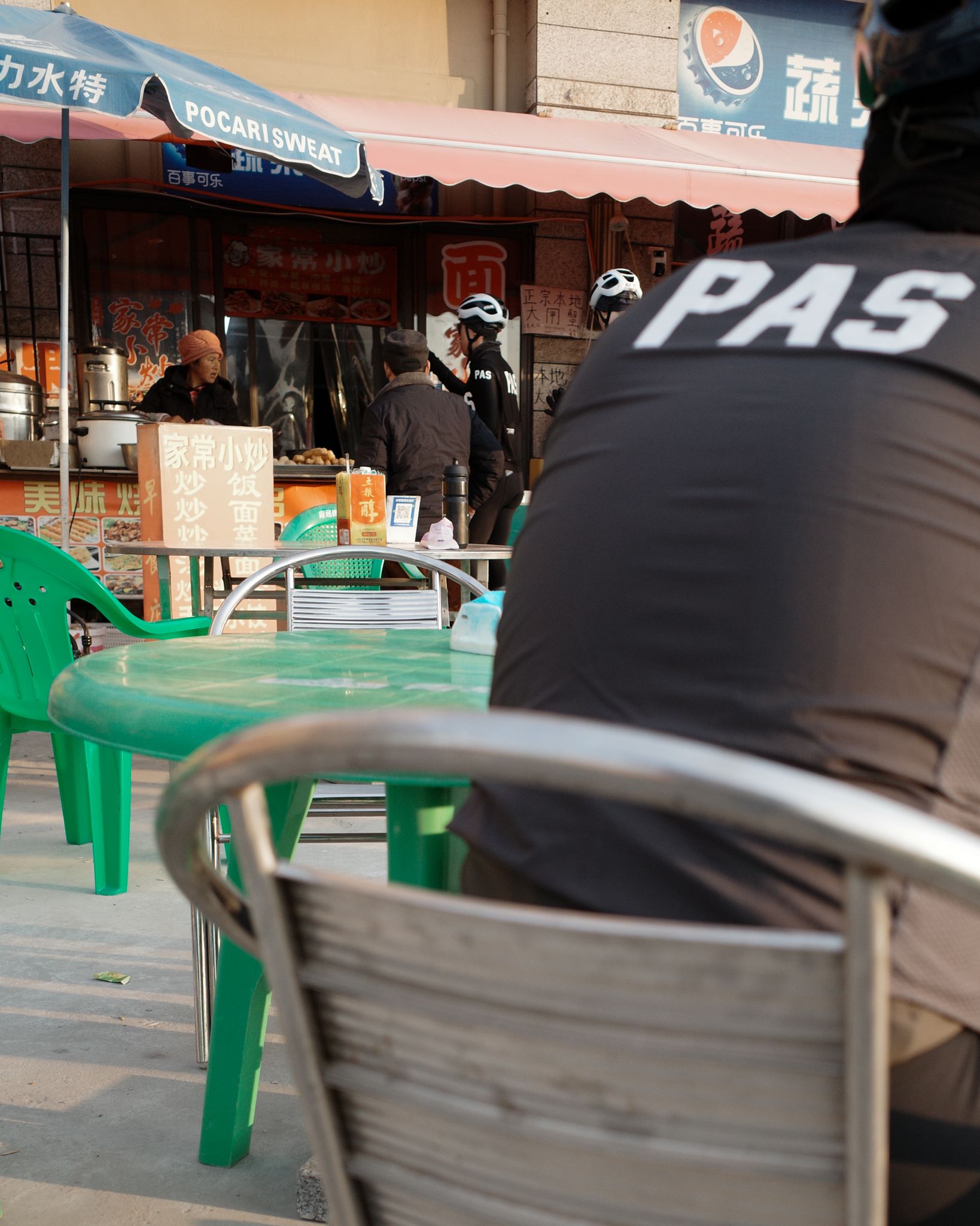 Model wearing black cycling jacket with logo at street food market