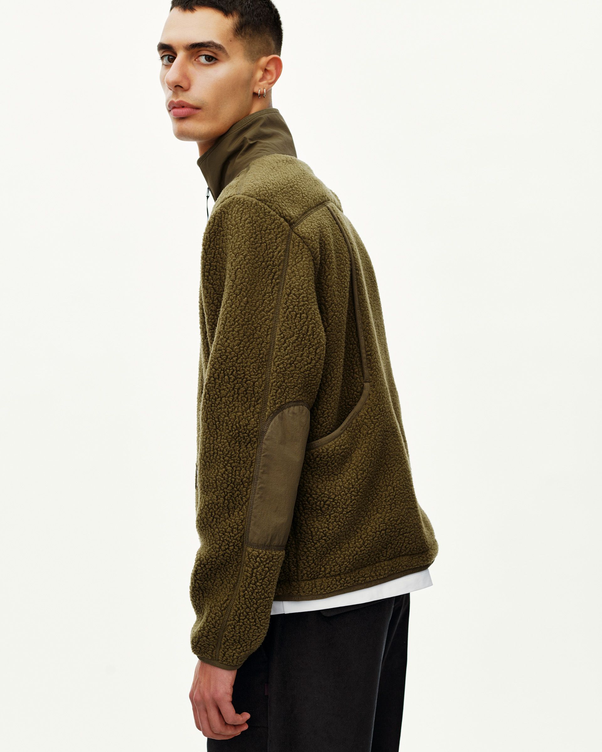 Deep Olive Off-Race Pile Fleece jacket on model, rear three-quarter view with contrast nylon elbow patch and collar