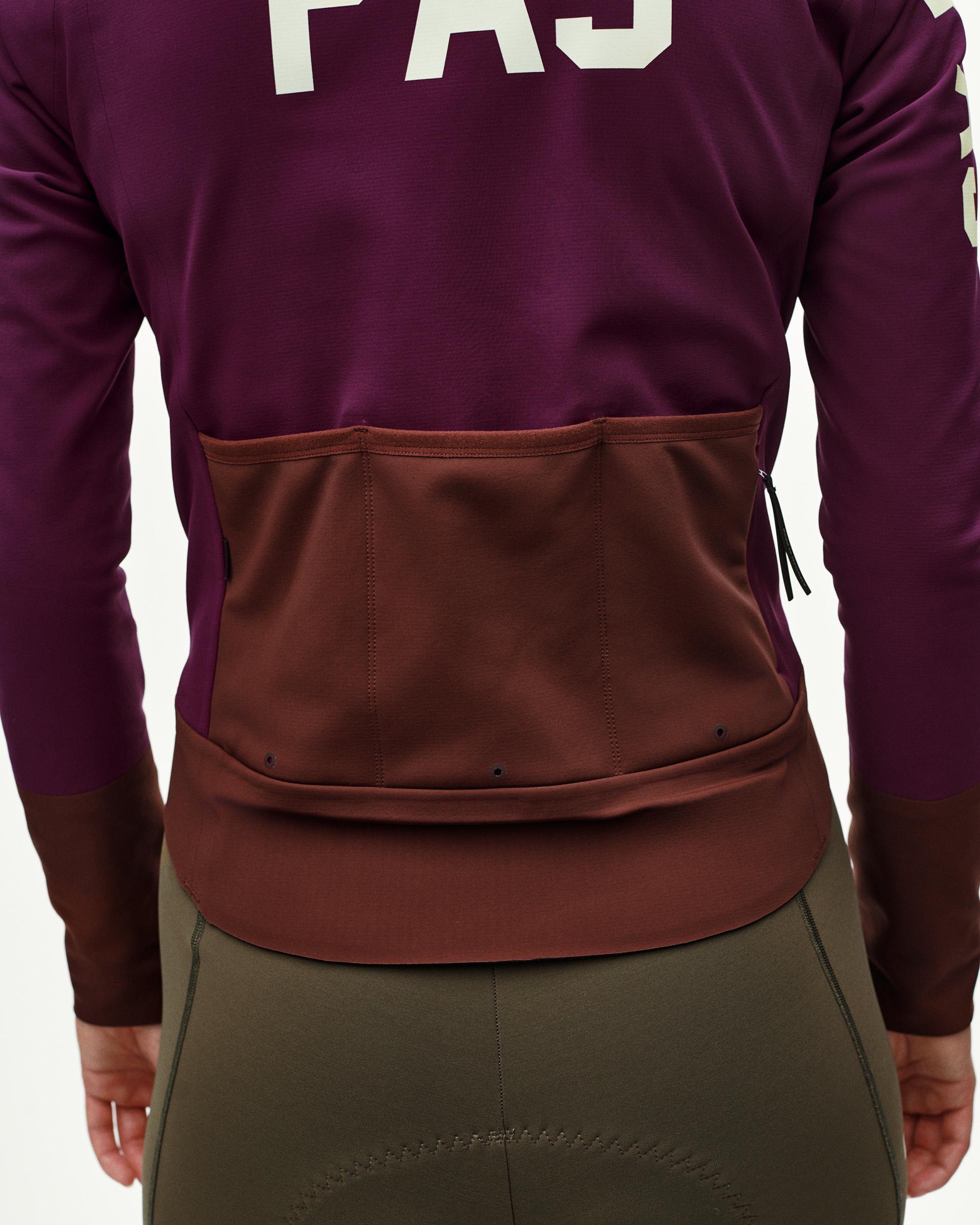 Dark Purple Mechanism women's thermal cycling jacket, rear detail on model showing contrast brown back pocket panel with zip