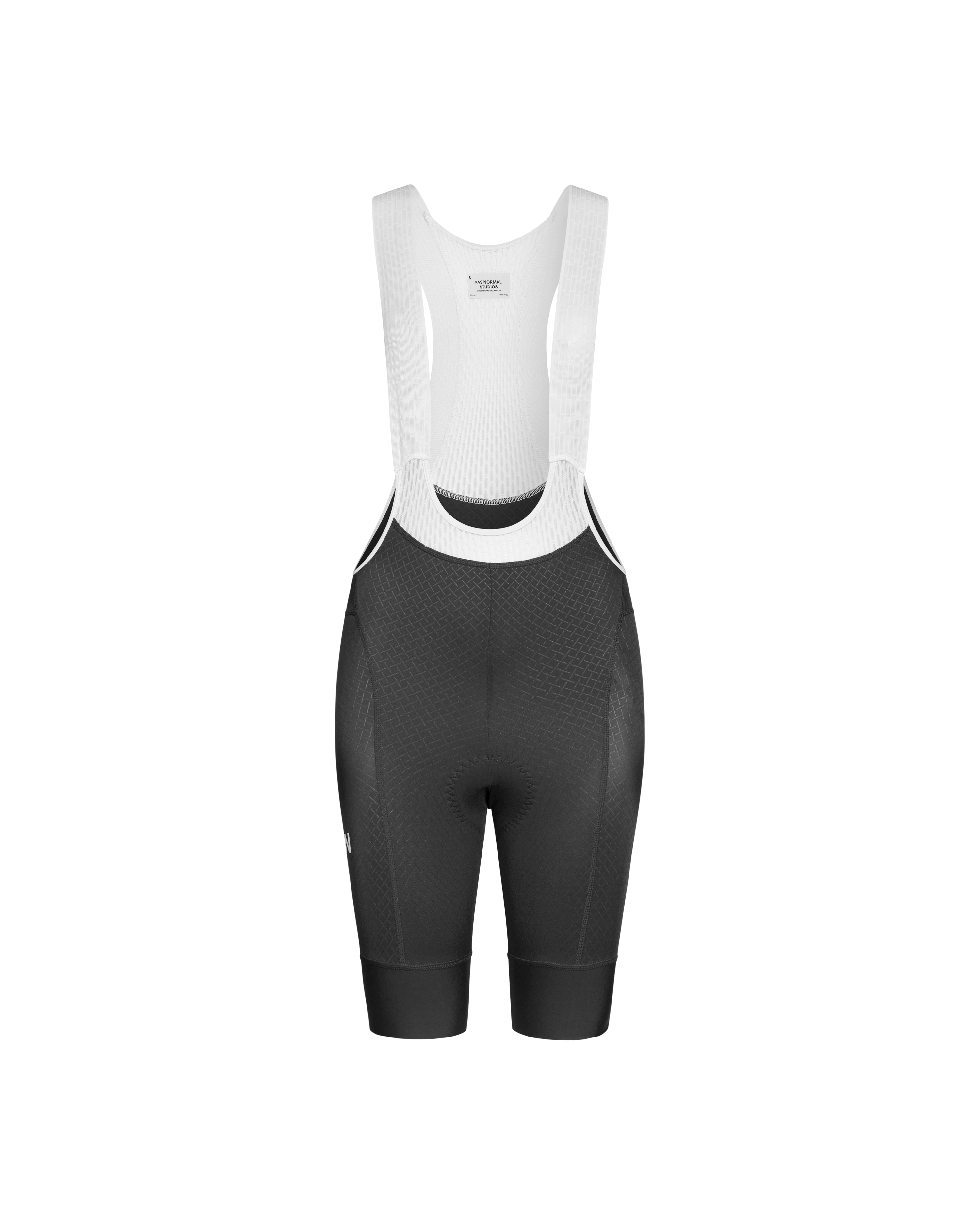 Black Mechanism cycling bibs, front flat lay with white shoulder straps and textured leg panels