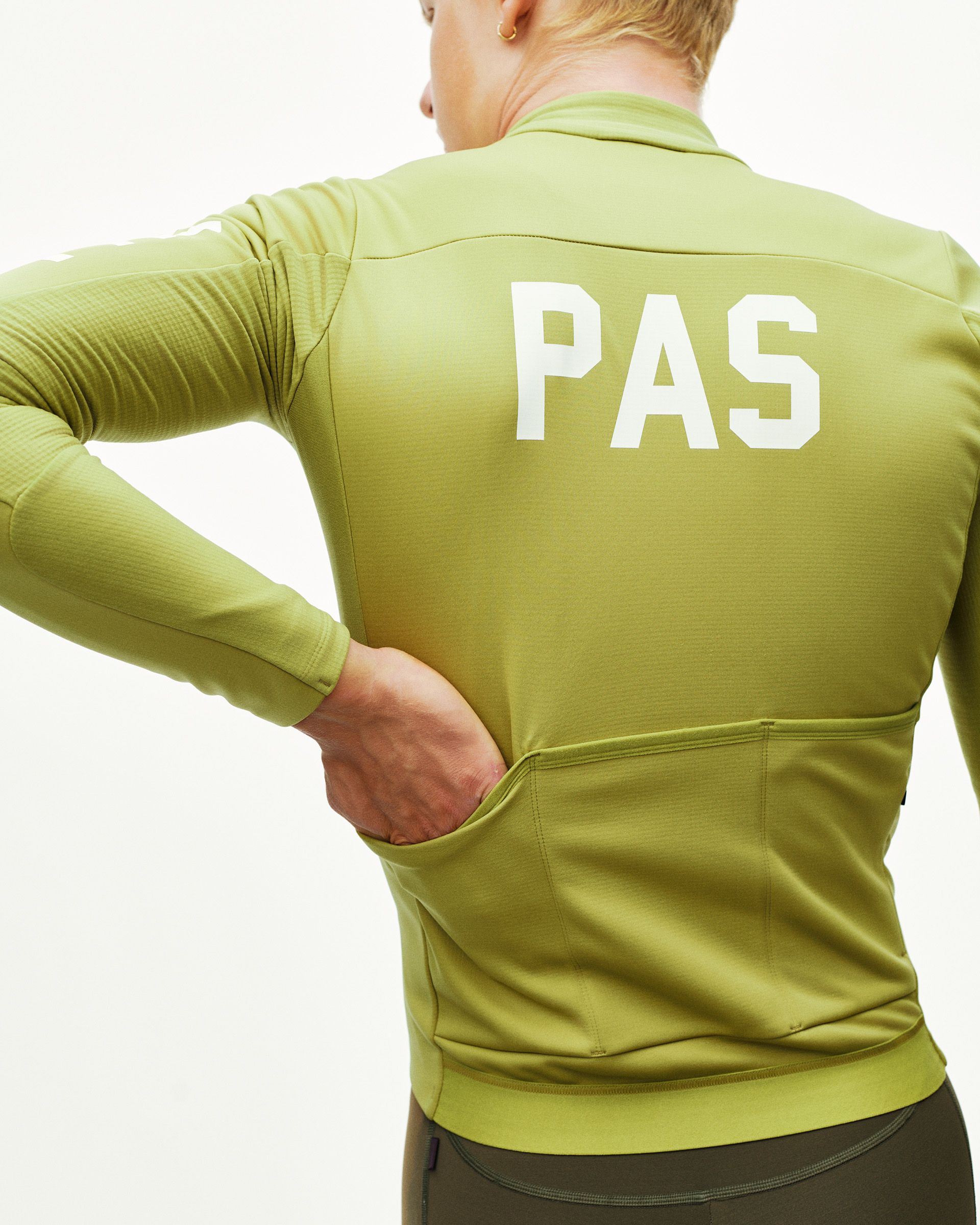 Dark Lime PAS Mechanism Thermal Long Sleeve cycling jersey, rear view on model with white PAS back print and rear pockets