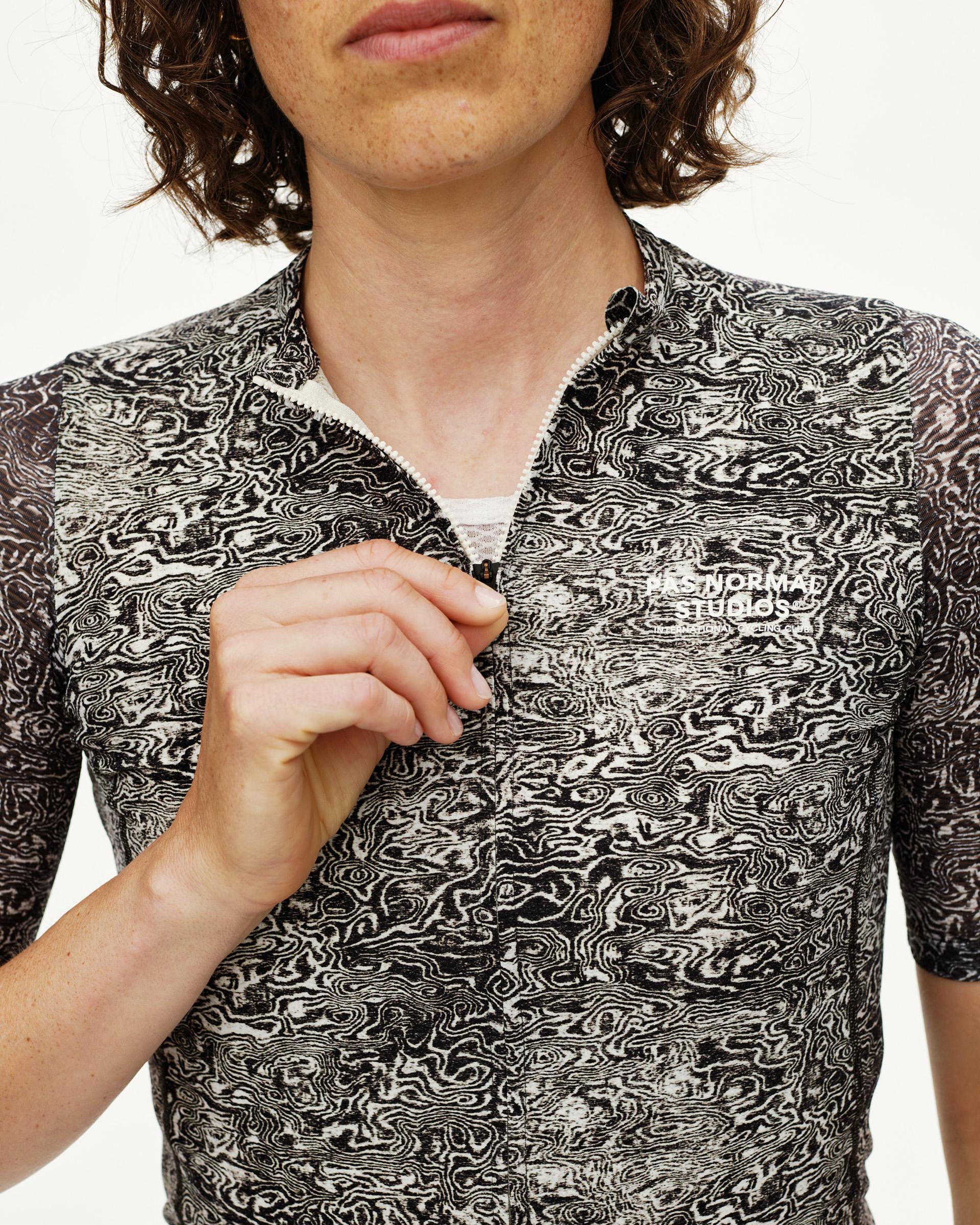 Off White Essential cycling jersey, front detail on model showing allover swirl print and zip pull