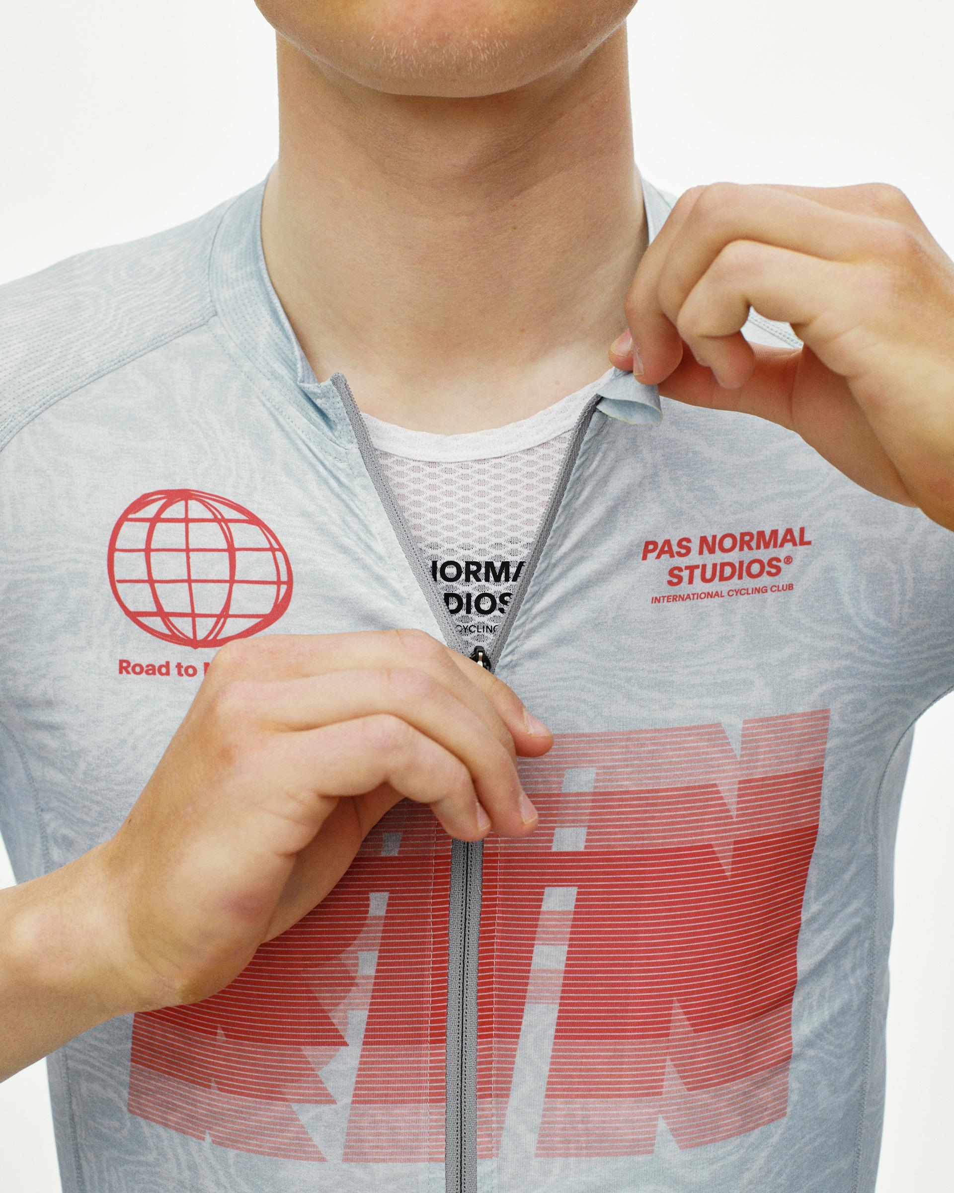 Light Aqua Mechanism cycling jersey on model, front detail view with red globe and large chest graphic print