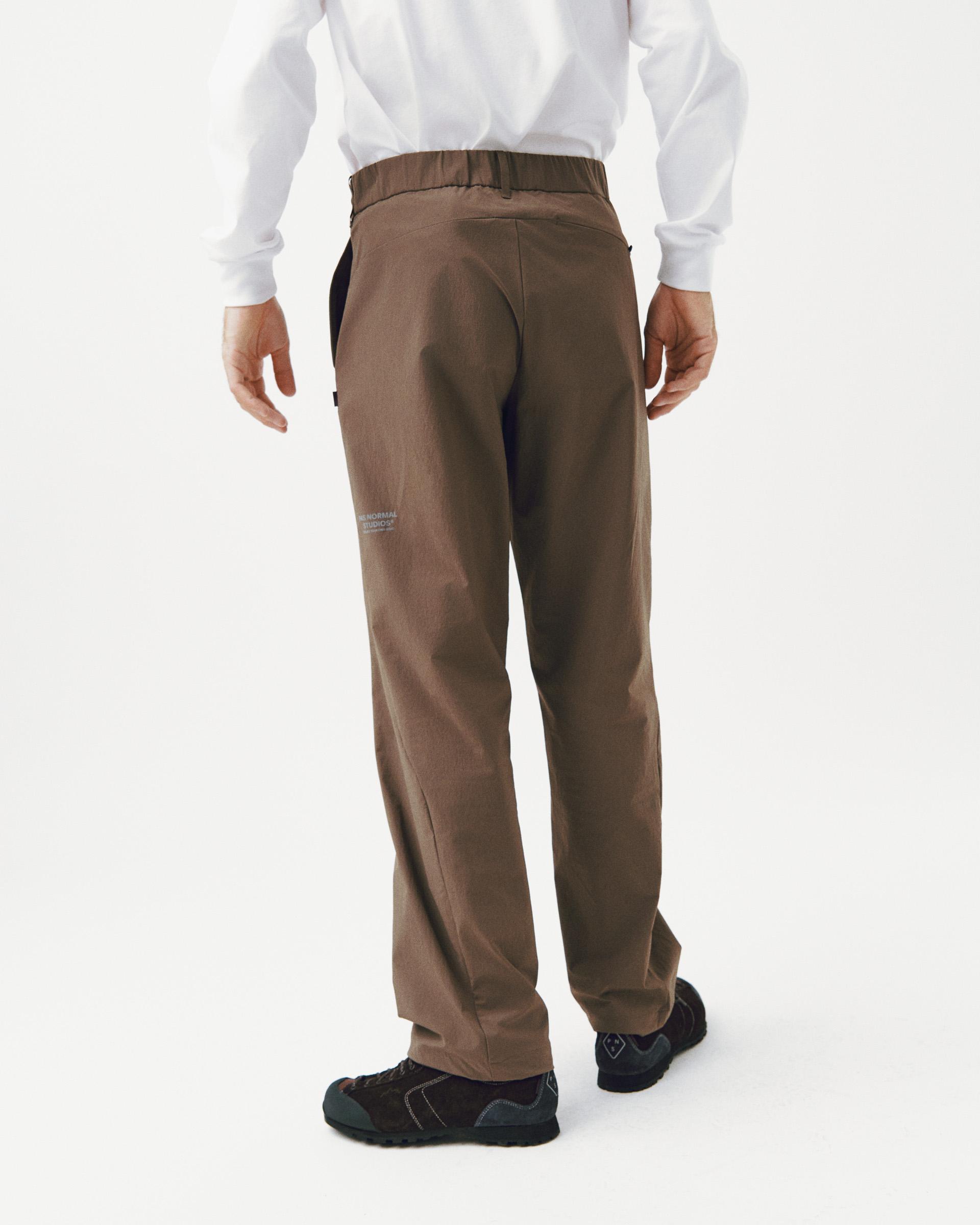 Brown Off-Race Tech pants on model, rear view with elastic waistband and relaxed fit