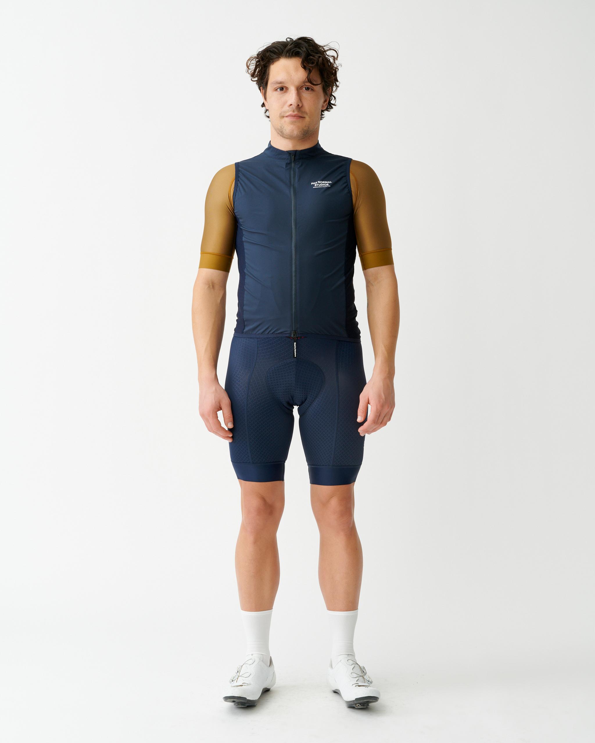 Navy Mechanism Stow Away gilet on model with mustard sleeves and full zip