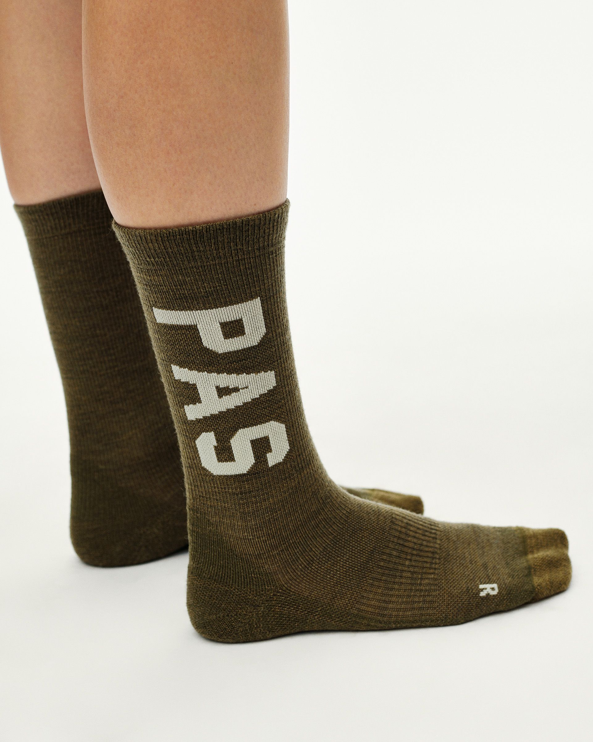 Moss Brown PAS Thermal Wool cycling socks on model, side view with white PAS leg print