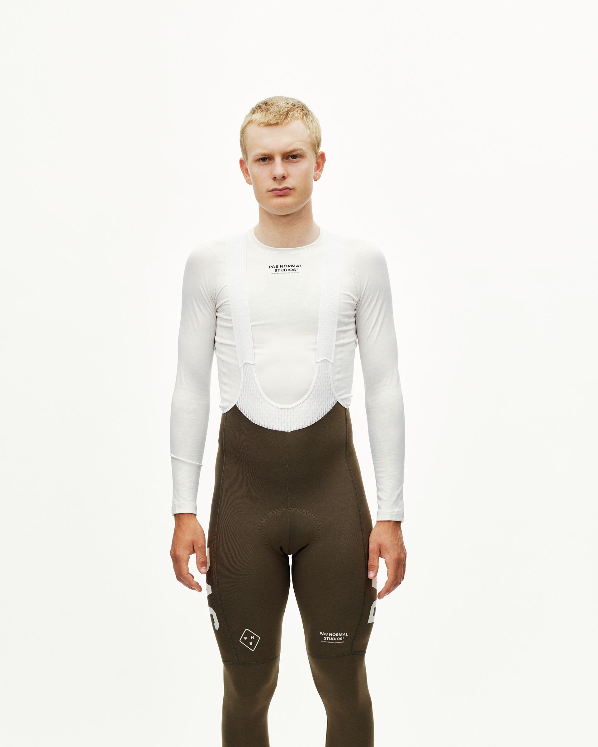 Dark Earth brown Mechanism PAS thermal long cycling bibs on model, front view with white bib straps