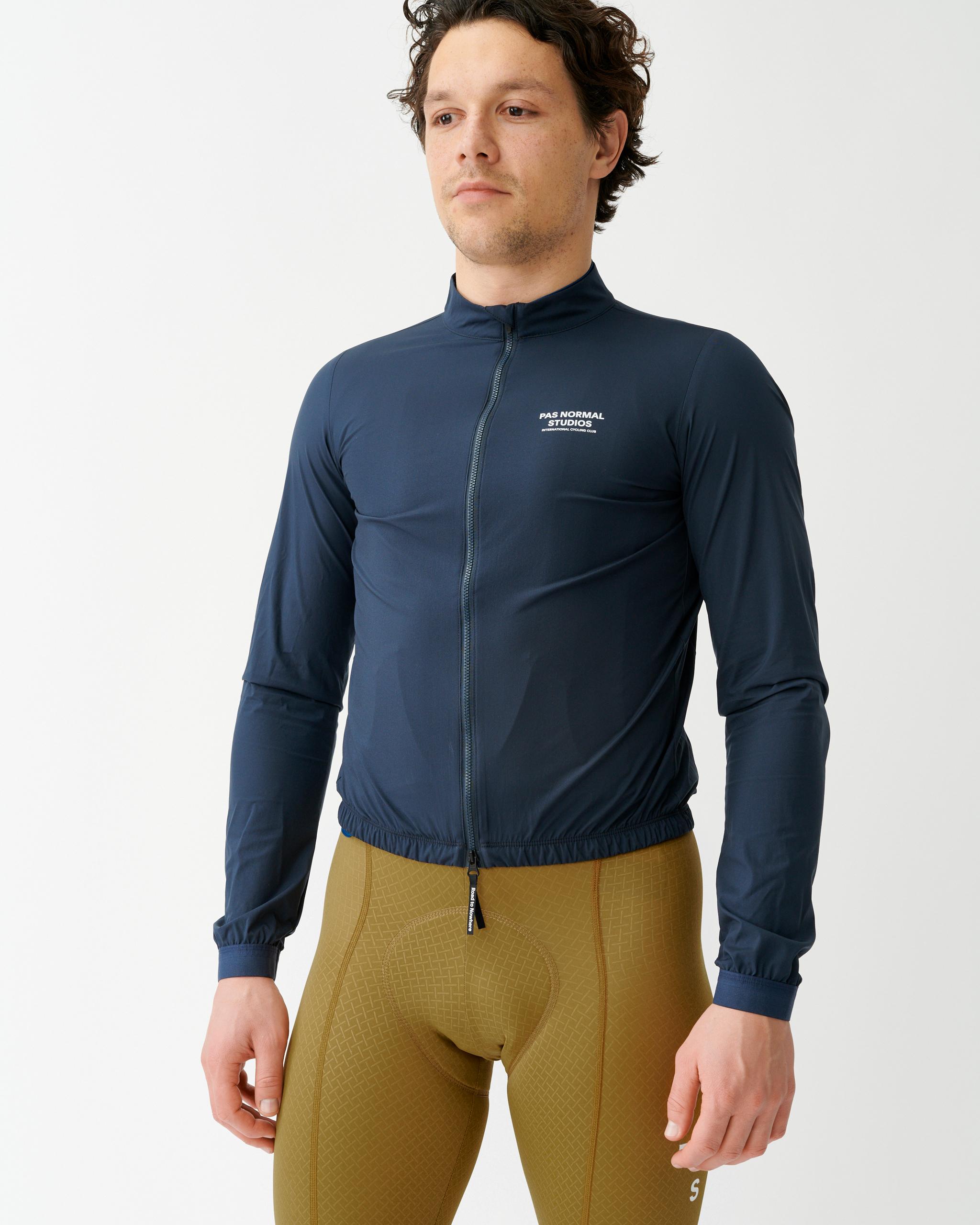 Navy Mechanism Stow Away cycling jacket on model with elastic waistband and cuffs