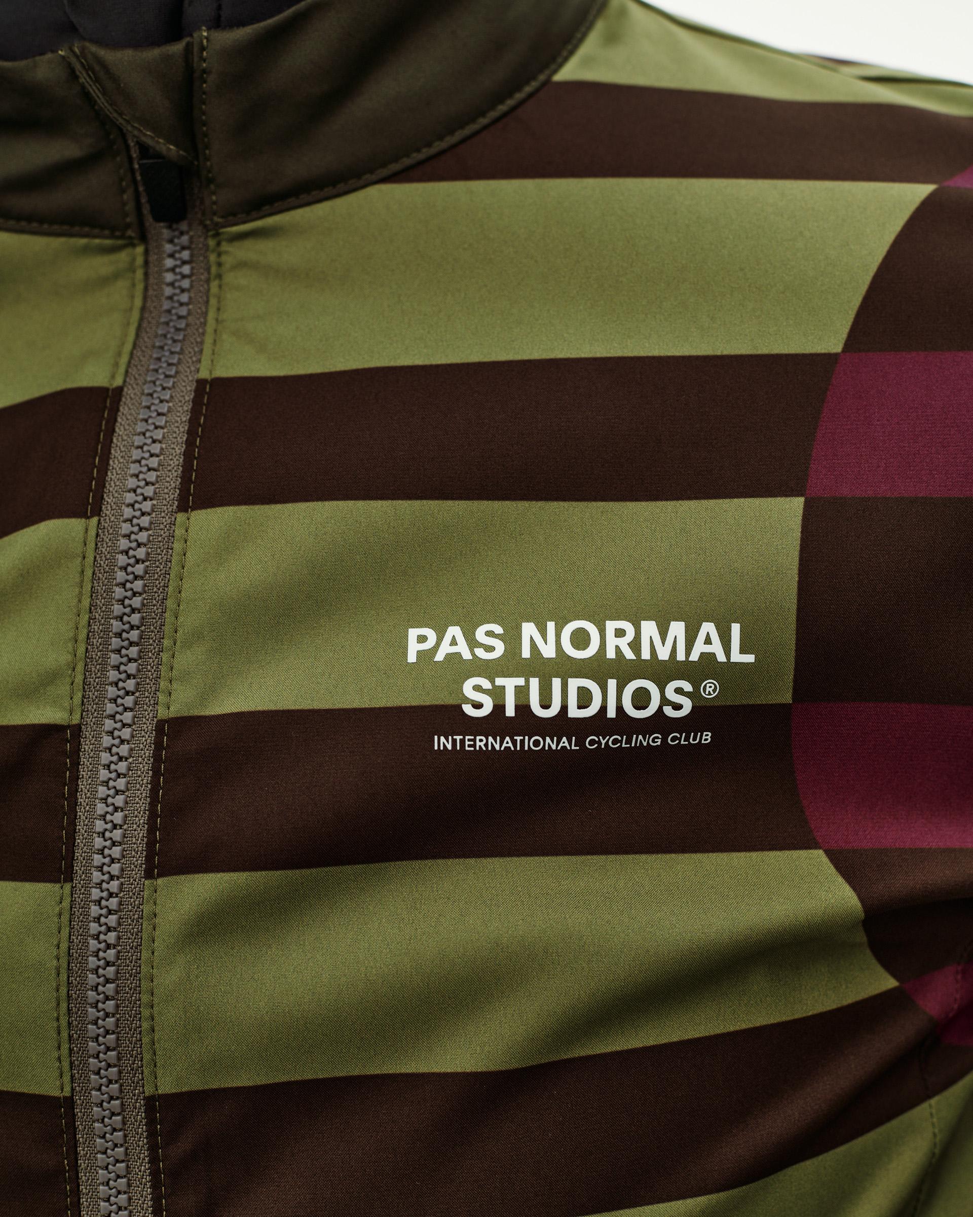 International Green Mechanism Stow Away cycling jacket, front detail with bold stripe print and chest logo